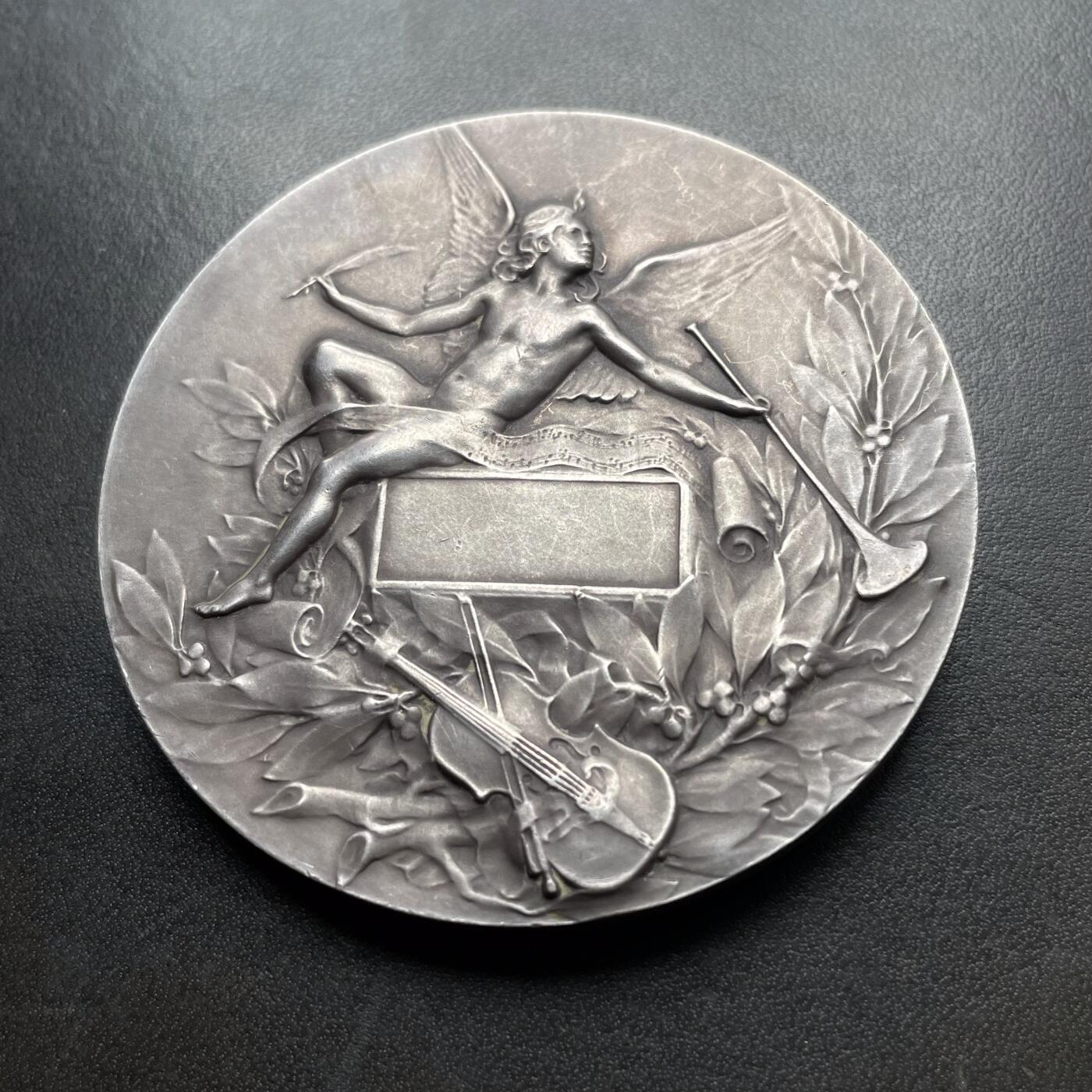 「木头集藏」章牌精品专场！ L.Coudray～法国音乐之神俄尔普斯大银章，直径：68 mm，162.3 g，边铭：丰饶角 ARGENT，名家高浮雕刻画作品，品相不错。俄耳甫斯，是古希腊神话中最著名的音乐家、诗人与先知，以超凡的音乐天赋和悲剧爱情闻名，太阳神阿波罗与缪斯女神卡利俄珀之子