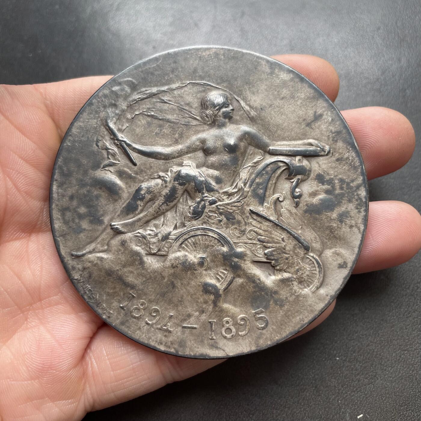 「木头集藏」章牌精品专场！ Daniel Dupuis～1902年法国汽车俱乐部云霄飞车大银章 ，直径：68mm，138g，边铭：丰饶角 ARGENT。经典的清凉美女章，实物品相不错，只是正面包浆不太均匀。根据背面铭文，此章是法国汽车俱乐部在1902年组织的一次剑术精英赛中授予拉博德伯爵的。1902年2月28日的《投石党报》刊文记载了这一盛事：“拉博德伯爵挥舞着剑，赢得了热烈的掌声”。  