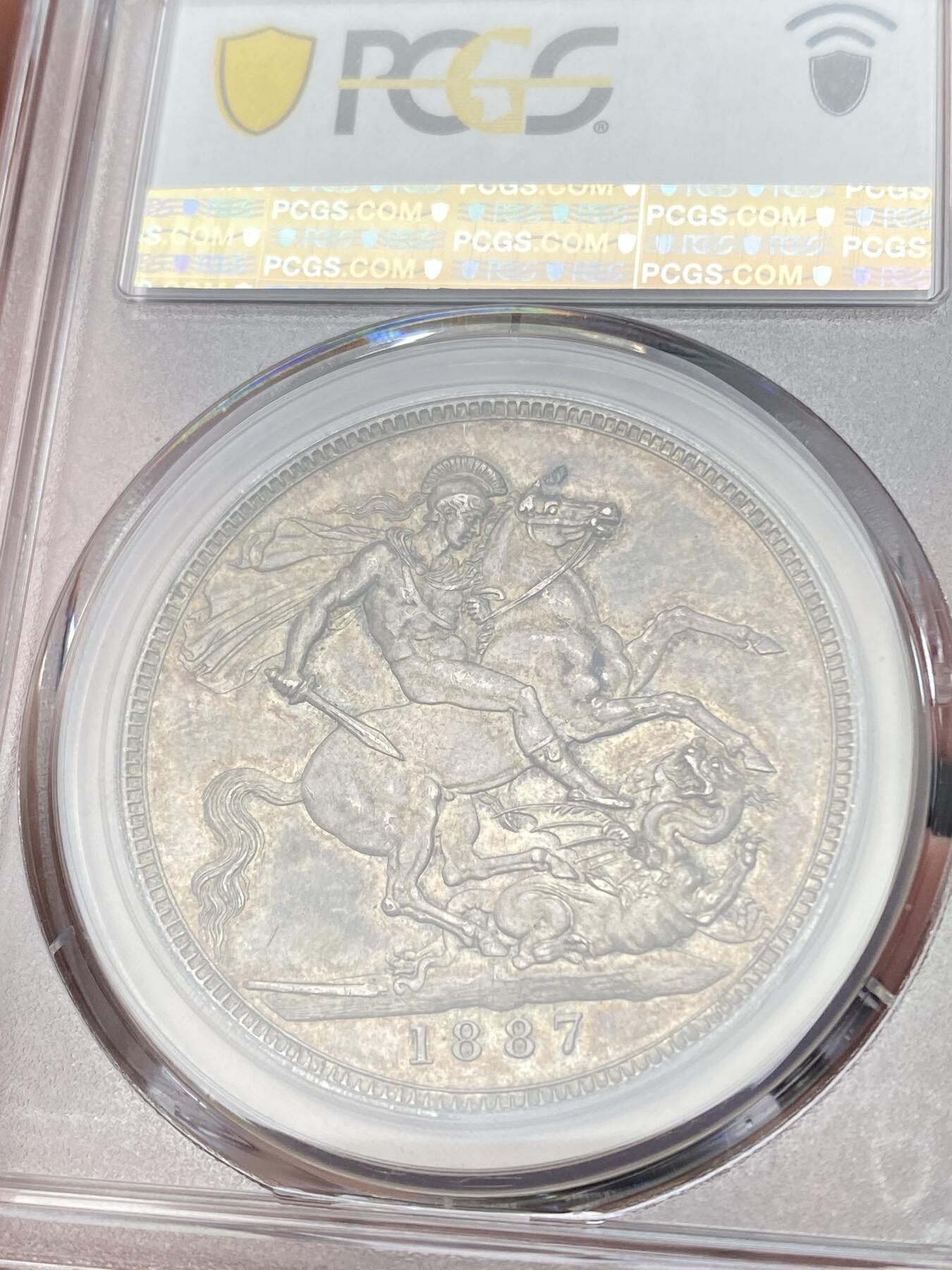 万国钱币拍卖第059期 PCGS AU58 1887年英国维多利亚女皇高冠马剑克朗  浮雕感圣乔治屠龙 原味淡彩状态舒适