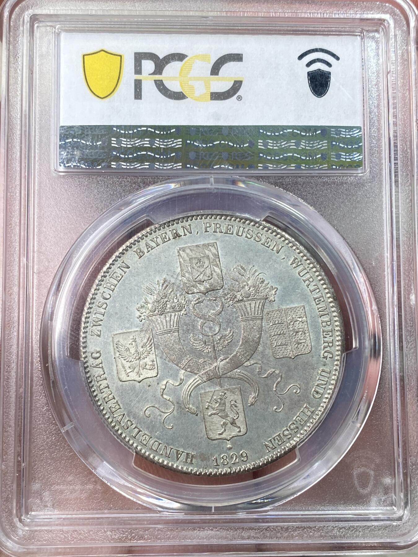 万国钱币拍卖第059期 PCGS MS65 1829年德国巴伐利亚路德维希一世贸易协定历史泰勒  纪念巴伐利亚、普鲁士、符腾堡和黑森之间的贸易协定泰勒 极其难得的BU级别历史大泰勒 银光在币面如流水般泻出  喷砂质感的四邦纹章紧密围绕在象征繁荣富裕的丰饶角周围 实物上手惊艳
