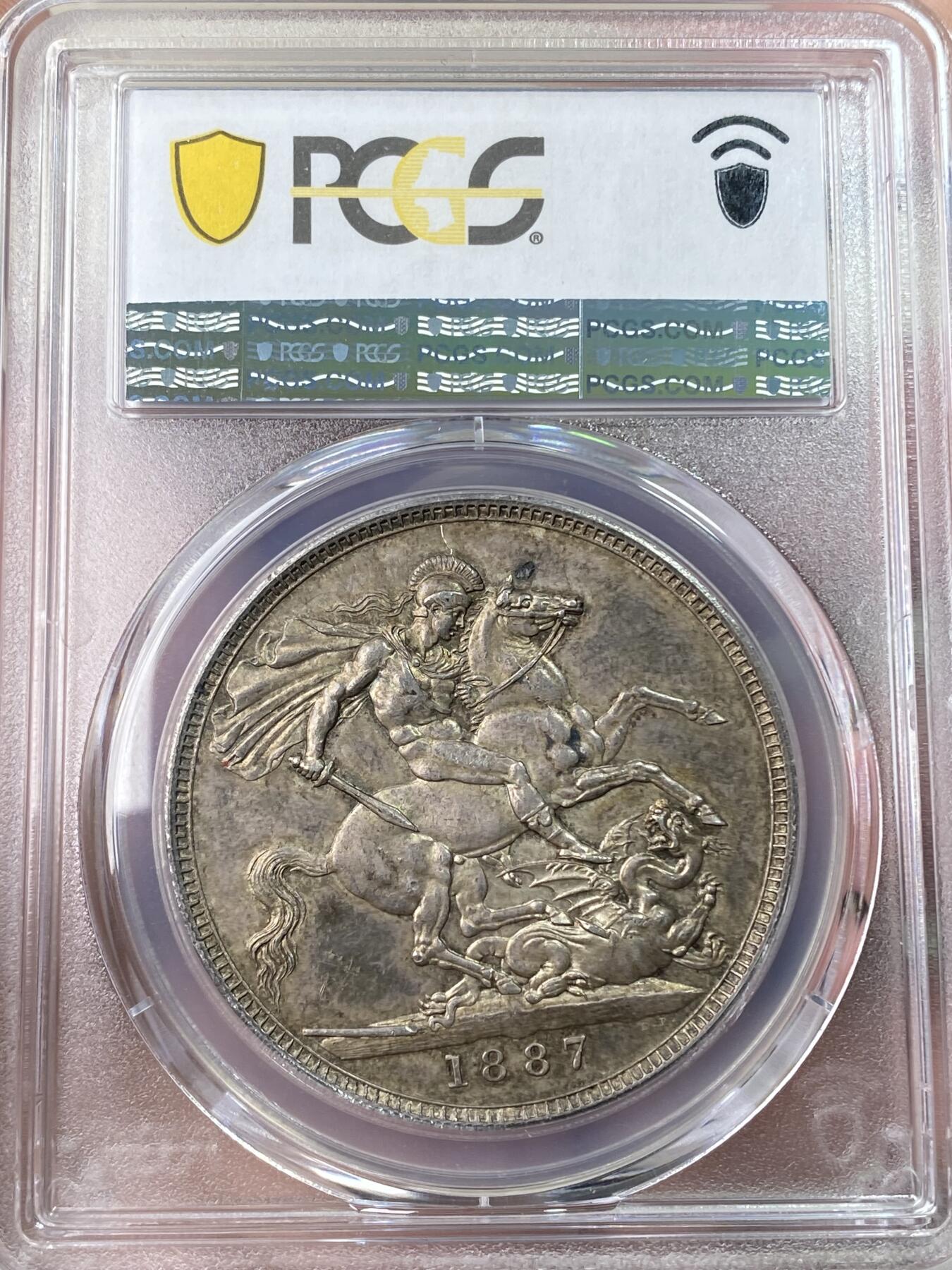 万国钱币拍卖第059期 PCGS AU58 1887年英国维多利亚女皇高冠马剑克朗  浮雕感圣乔治屠龙 原味淡彩状态舒适
