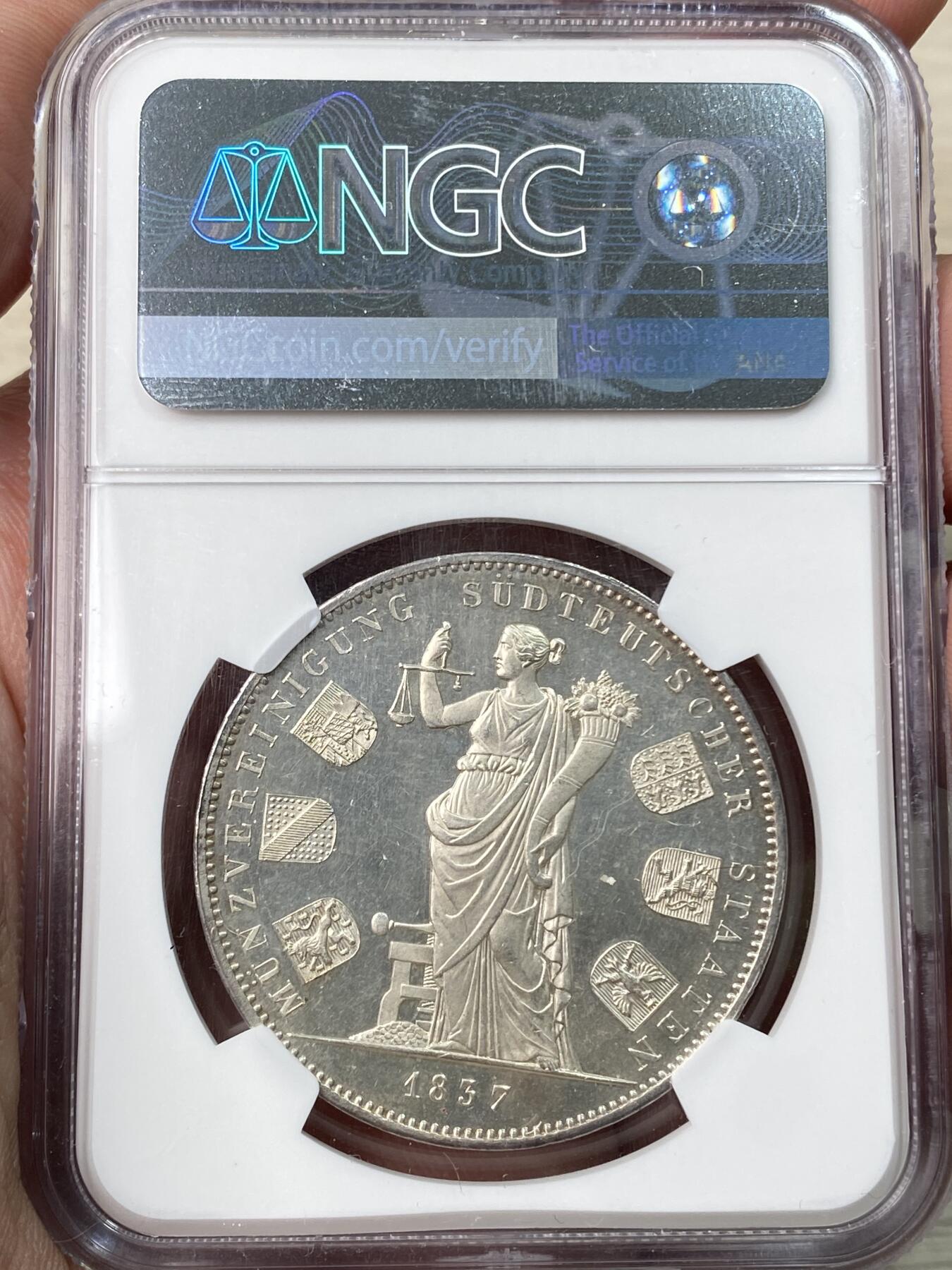 万国钱币拍卖第059期 NGC MS65 1837巴伐利亚路德维希一世货币联盟历史2泰勒 纪念1837年南德六邦在慕尼黑签署《慕尼黑货币协议》，决定停发王冠泰勒，转而以传统的古尔登为单位发行货币，2泰勒面值等于3.5古尔登，而此枚历史2t也就成为了邦国协议2泰勒的开山之作。 类镜面喷砂PL质感顶级BU状态 NGC唯一亚军分