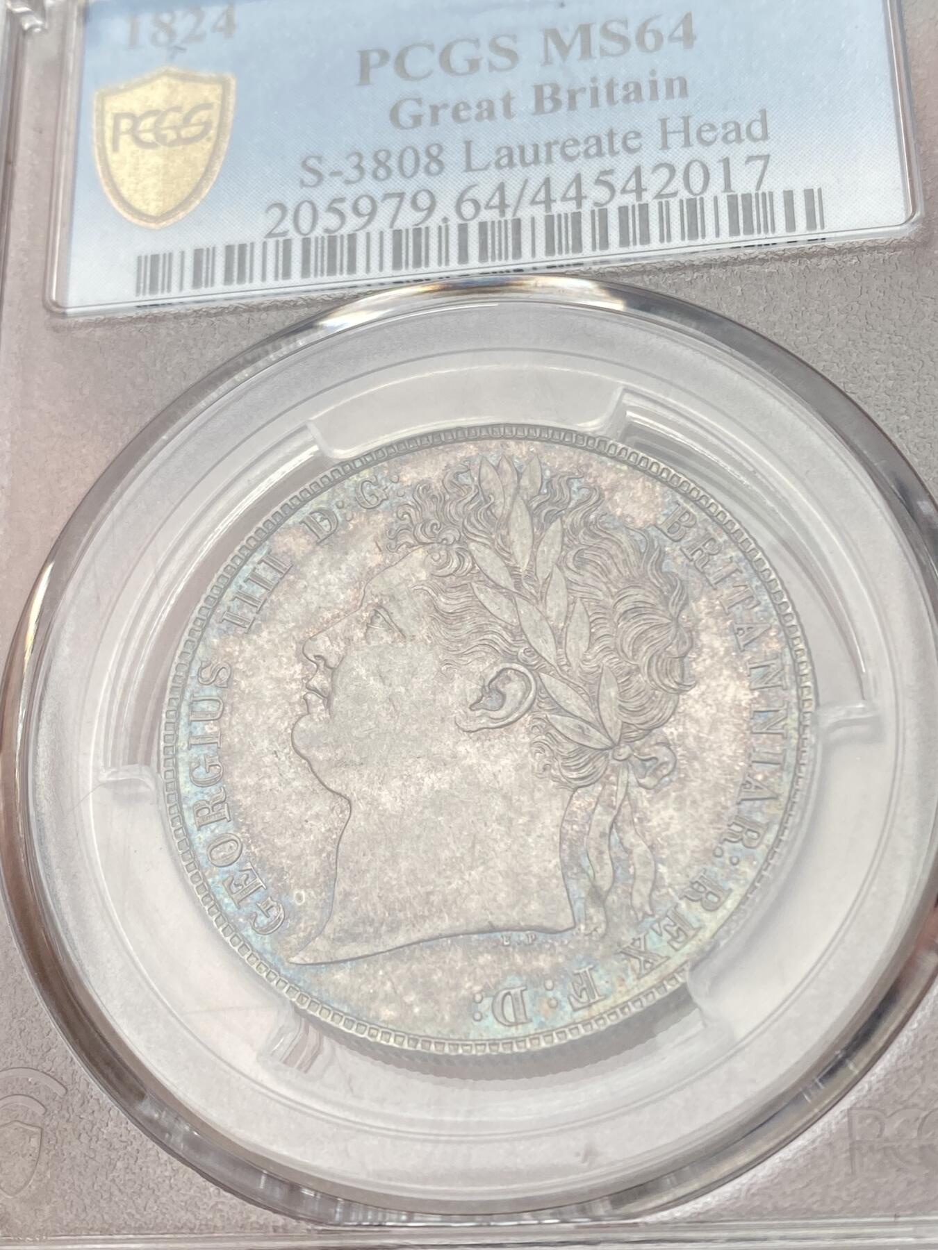 万国钱币拍卖第059期 PCGS MS64 1824年英国乔治四世嘉德1/2克朗银币 乔四流通半克朗中难度最大的一款 原味英式天鹅绒幻彩 丝绸转光底板 非常原始的状态 PC唯二冠军分 可遇不可求的典藏品质