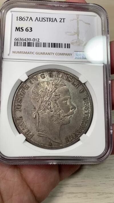万国钱币拍卖第059期 NGC MS63 NGC MS63 1867年奥地利弗朗茨一世双头鹰流通2泰勒 维也纳货币协议的产物 和常见的德国2泰勒形制一般无二 除了1857年发行的大名誉品南方铁路2泰勒外 奥地利只在1865~67三年间发行过流通2泰勒（其中65年为早期头像版 ） 1867年的发行量为8300枚 在流通2泰勒中算是非常少的存在 极其原味的纸袋包浆 完全未动过的原始状态 HA一月拍卖64分成交价8540美金