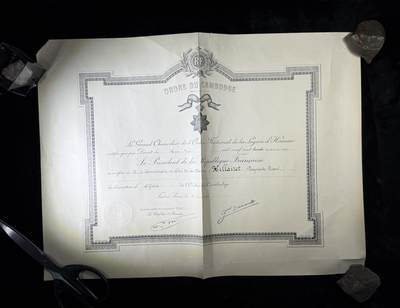 戎马世界章牌大赏第110期 - 法属柬埔寨王国军官级王冠勋章证书，有折痕破损，属于法国海军专员，有得主相关履历，得主1939年晋升为首席专员，曾在远东的“雷居勒斯号”巡洋舰服役，随后登上“恩特卡斯特奥号”驱逐舰与“巴黎号”战列舰，在“圣女贞德号”巡洋舰度过两年时光后，他曾短暂负责学员晋升考核