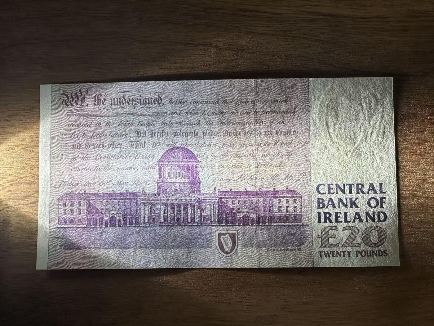 徐霞客拍卖首拍 	爱尔兰	P-77b 1999年20镑	MRV763520 unc-	纸币正面背景是奥康奈尔的故乡——凯里郡的Derrynane House（现Derrynane Abbey），建筑细节中暗藏“£20”微缩文字防伪；背面则是都柏林的四法院（Four Courts），这座建筑不仅是爱尔兰最高法院所在地，其墙面上的弹孔更是1916年复活节起义的历史印记。