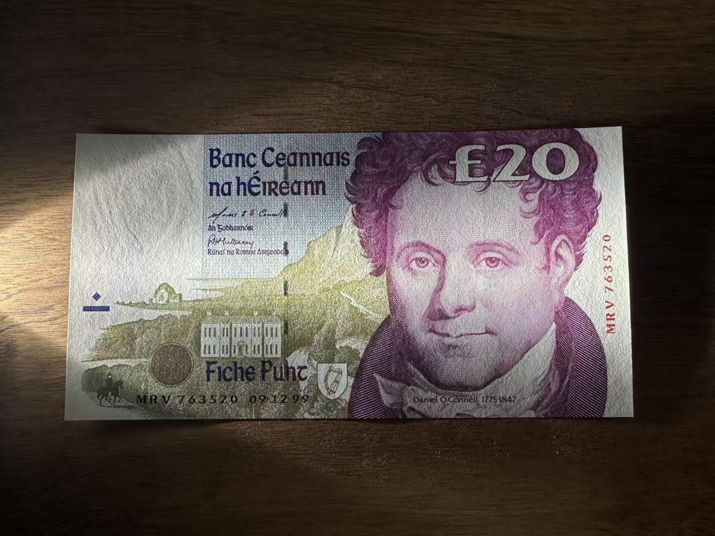 徐霞客拍卖首拍 	爱尔兰	P-77b 1999年20镑	MRV763520 unc-	纸币正面背景是奥康奈尔的故乡——凯里郡的Derrynane House（现Derrynane Abbey），建筑细节中暗藏“£20”微缩文字防伪；背面则是都柏林的四法院（Four Courts），这座建筑不仅是爱尔兰最高法院所在地，其墙面上的弹孔更是1916年复活节起义的历史印记。