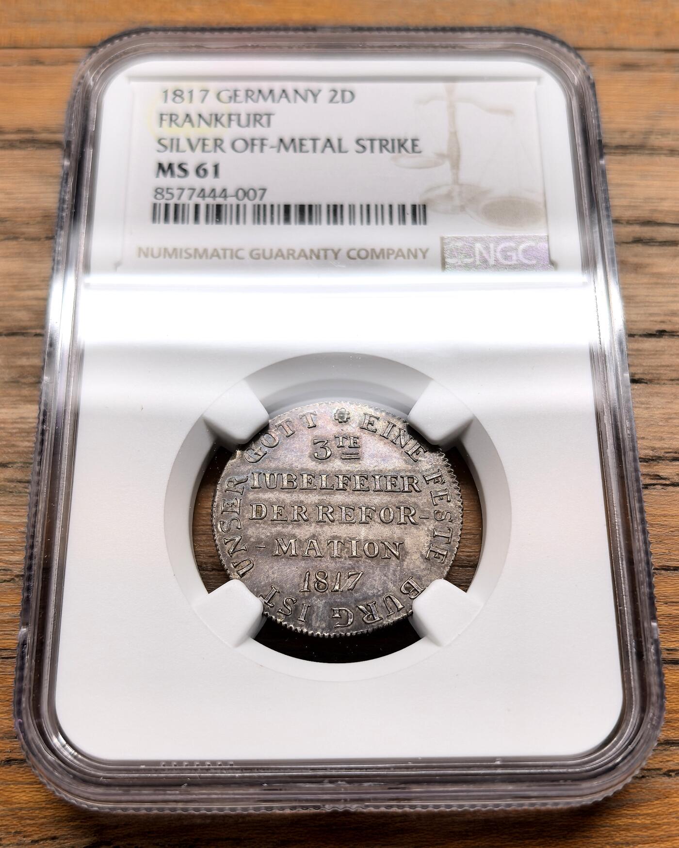 凡希社世界钱币微拍第三百十九期 1817德国法兰克福宗教改革300周年银质试铸样币NGC-MS61，珍稀品种。正面铭文意为“宗教改革第三次庆典 1817”，边缘环绕“UNSER GOTT IST EINE FESTE BURG”（我们的上帝是坚固的堡垒），这句源自马丁·路德的赞美诗，是宗教改革的标志性口号。