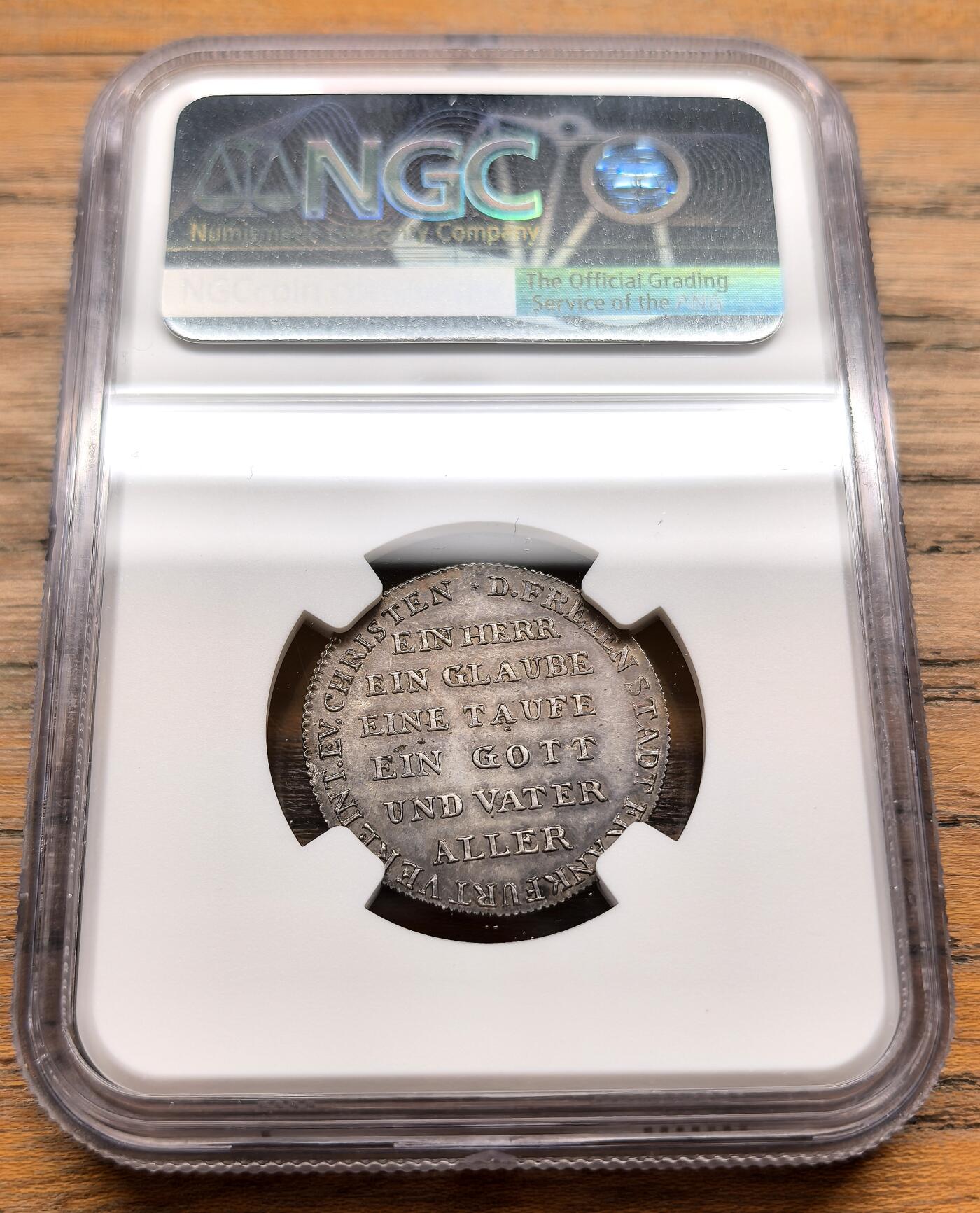 凡希社世界钱币微拍第三百十九期 1817德国法兰克福宗教改革300周年银质试铸样币NGC-MS61，珍稀品种。正面铭文意为“宗教改革第三次庆典 1817”，边缘环绕“UNSER GOTT IST EINE FESTE BURG”（我们的上帝是坚固的堡垒），这句源自马丁·路德的赞美诗，是宗教改革的标志性口号。