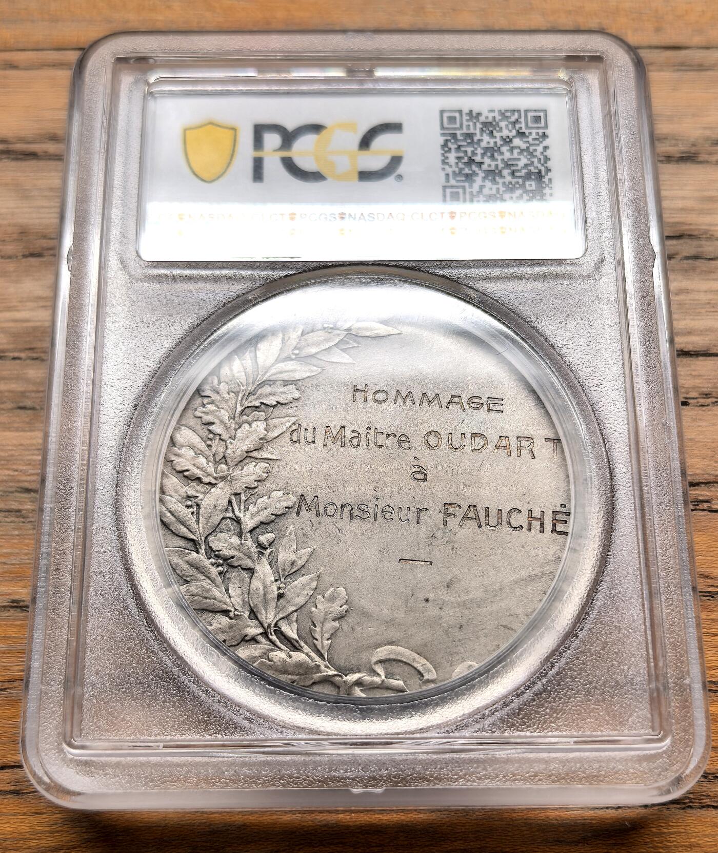凡希社世界钱币微拍第三百十九期 1880法国里尔市纪念银章PCGS-SP63，-正面浮雕为里尔市的拟人化女性形象，背景是里尔的城市景观，包括标志性的钟楼与古建筑群，边缘装饰有花卉与工业元素，象征里尔的繁荣与活力。