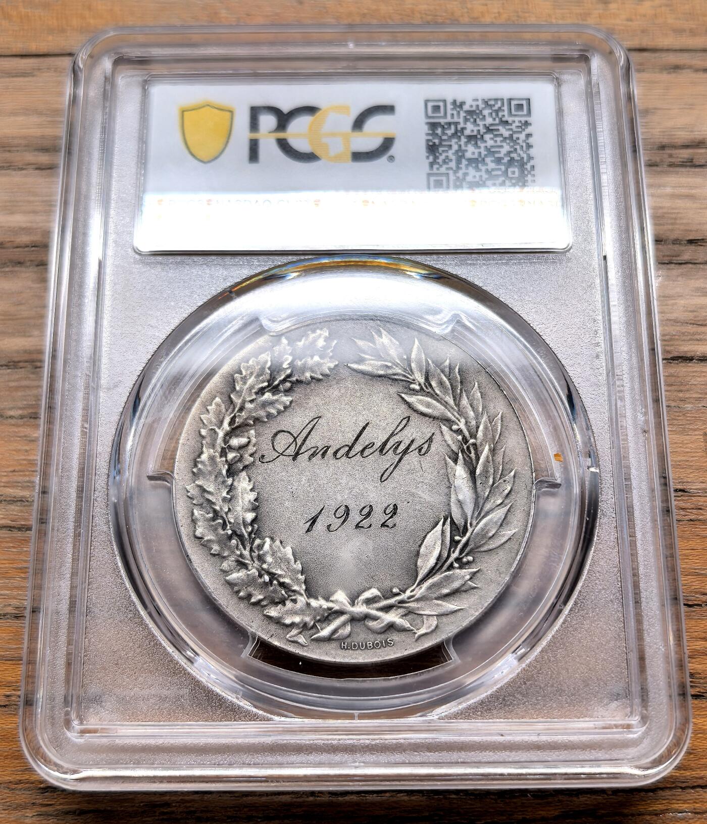 凡希社世界钱币微拍第三百十九期 1922法国昂热利体操运动会哑光工艺银质样章PCGS-SP63，正面浮雕刻画了三位核心人物：左侧是象征力量的男性形象，中间是代表运动员的青年，右侧是手持阿斯克勒庇俄斯之杖（蛇杖）的健康女神许癸厄亚。上方铭文“ROBVR HYGIA”意为“力量与健康”，下方铭文“PRO PATRIA”意为“为了祖国”，体现了当时法国将体育与爱国精神绑定的理念。