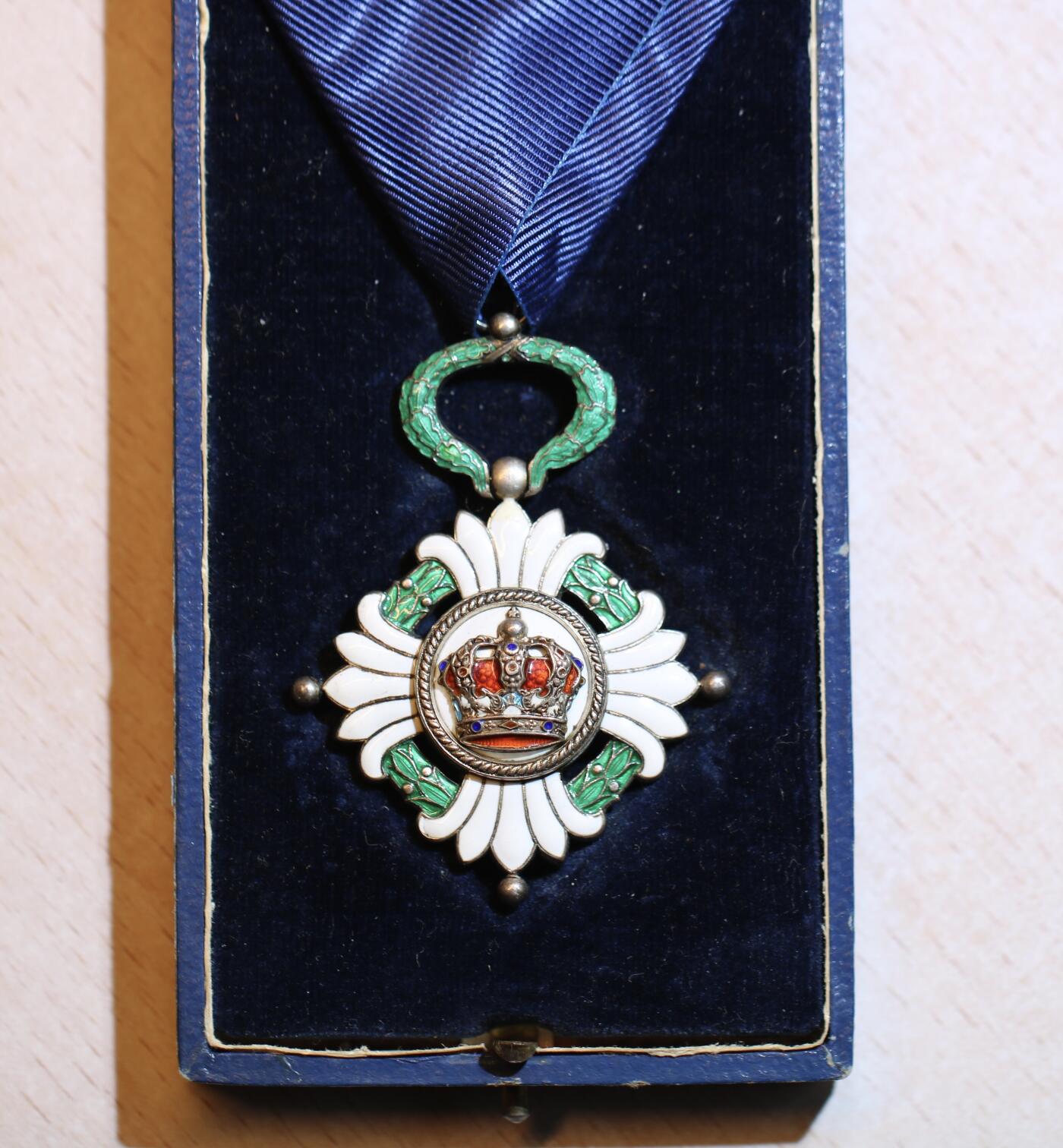 大猫徽章拍卖 第287期 南斯拉夫皇冠勋章，四级，带原装盒。勋章珐琅工艺精美，无缺损。盒身覆以蓝色皮革，盒盖上饰有金色字样。盒内衬以天鹅绒和缎面。白色盒盖上印有瑞士制造商“Huguenin Freres & Co.”的标记，一处为法语，另一处为南斯拉夫语译文。绶带略有撕裂。整套勋章品质上乘，保存完好，虽有岁月痕迹，但仍不失韵味。珐琅局部有修复