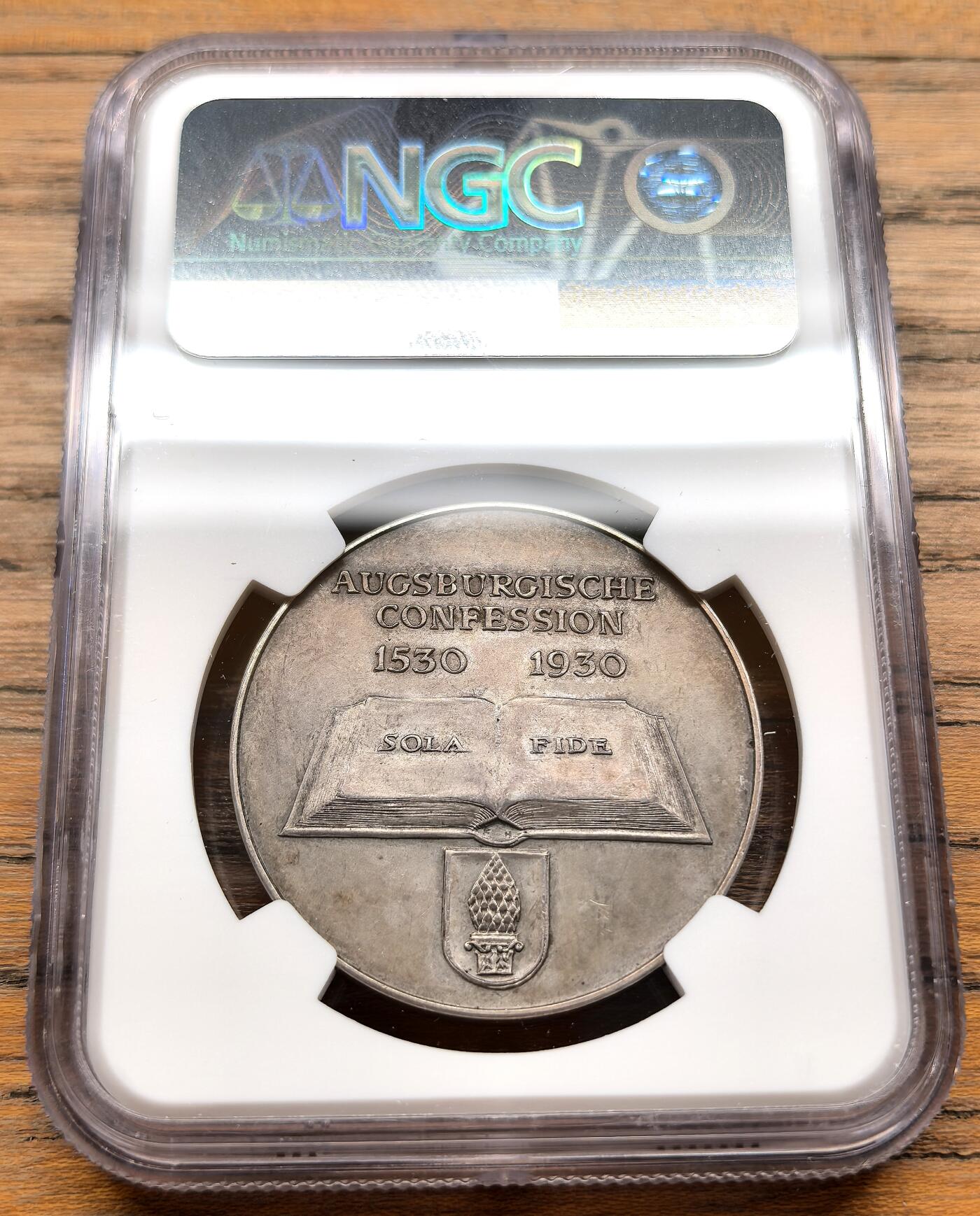 凡希社世界钱币微拍第三百十九期 1930德国奥格斯堡信纲400周年纪念银章NGC-MS62，正面浮雕为马丁·路德与奥格斯堡信纲的主要起草人菲利普·梅兰希通的双人肖像，二人是宗教改革的核心领袖。背面中央描绘了一本摊开的圣经，刻有新教核心教义“SOLA FIDE”（唯独因信），下方是奥格斯堡市的市徽。双头像版本稀见。