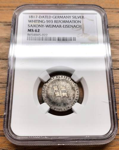 凡希社世界钱币微拍第三百十九期 - 1817年德国萨克森-魏玛-艾森纳赫宗教改革300周年杜卡特型银质币章NGC-MS62，正面中央图案为一本摊开的圣经，四周配以放射状芒线，环绕铭文“DEIN WORT BLEIBE IN EWIGKEIT”（你的话语直到永远），直接呼应了宗教改革以《圣经》为核心的理念，宗教改革庆典系列较为稀见的品种。