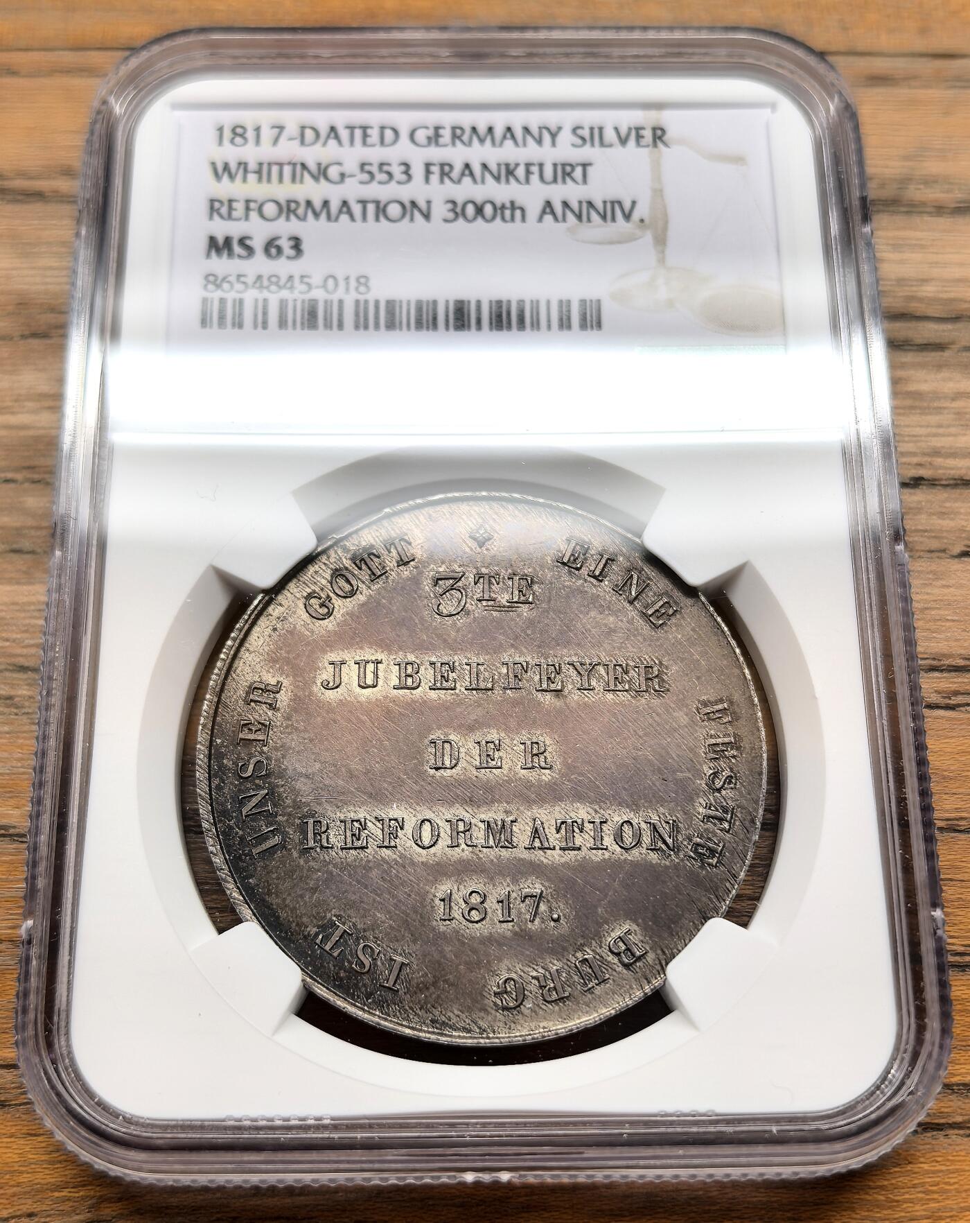 凡希社世界钱币微拍第三百十九期 1817德国法兰克福宗教改革300周年纪念泰勒型银质币章NGC-MS63，该系列的大规格更为罕见，背面中央铭文为“EIN HERR, EIN GLAUBE, EINE TAUFE, EIN GOTT UND VATER ALLER”，源自《圣经·以弗所书》，意为“一主、一信、一洗、一神，就是众人的父”，体现了新教的核心教义。