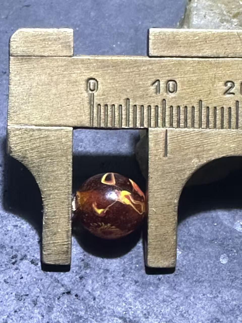 建国前后库存琥珀色祥云纹立体凤眼琉璃珠一颗，