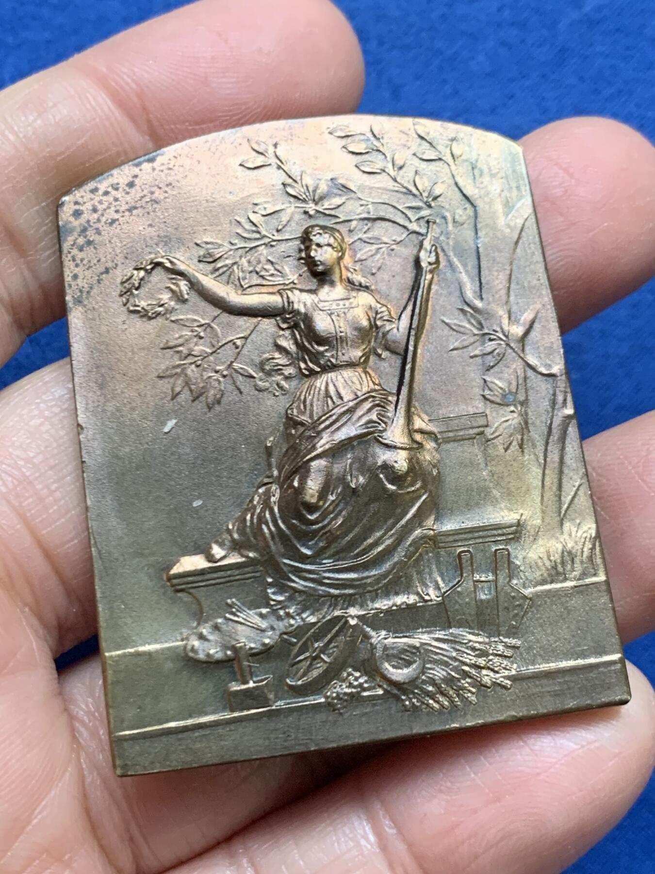 《竞宝斋》第461场 周日，周一，2场连拍 （全场包邮）欢迎送拍 法国尚贝里博览会铜章，一位古典女性形象，手持花环（象征荣誉或胜利），身旁有树枝装饰，下方有植物和器物图案（象征艺术或文化），49.7克，40*52.2mm，丰饶角铜标。