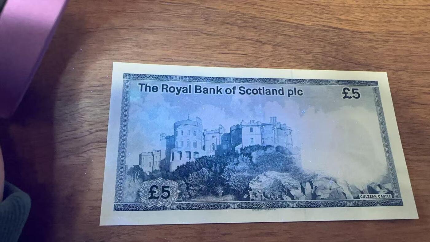 徐霞客拍卖首拍 苏格兰/皇家银行P-342c 1985年5镑	B/54 897513 unc-	这张5英镑纸币是早期流通版别，票面保留了时任常务董事的手写签名，后续版本已更换签名样式。设计上延续了地方货币的独特防伪与纹饰风格，承载着独特的货币发行历史。其收藏价值源于早期版别存世量少，手写签名设计稀缺，品相完好的该版别在收藏市场具备稳定升值潜力。