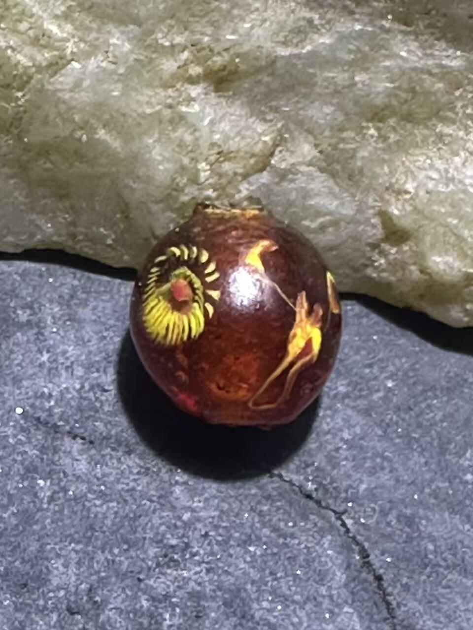 建国前后库存琥珀色祥云纹立体凤眼琉璃珠一颗，