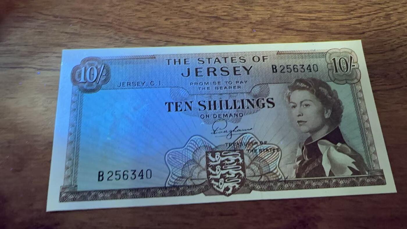 徐霞客拍卖首拍 泽西岛	P-7 1963年10先令	UNC- B256340			发行于20世纪中后期，是泽西岛当时流通的法定货币。它融合了英联邦货币风格与本土标识的设计，以君主肖像为核心元素，兼具流通功能与身份象征意义，见证了泽西岛货币体系的独立发展与英联邦金融关联，是研究该地区金融史与殖民文化传承的实物佐证。其收藏价值源于存世量稀少，在小众地域货币收藏中独具辨识度。	