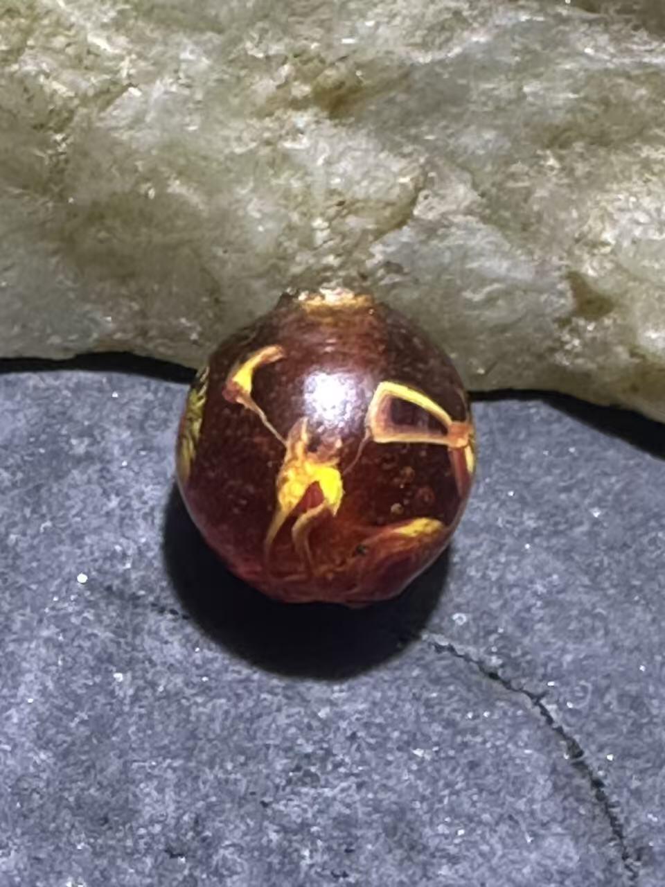 建国前后库存琥珀色祥云纹立体凤眼琉璃珠一颗，