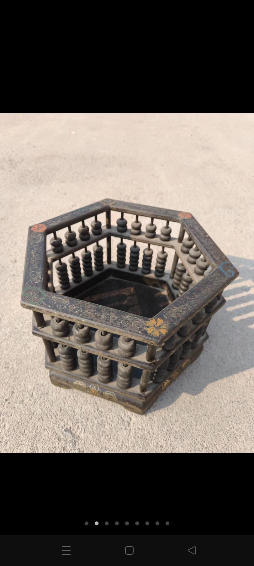 六角形算盘摆件，以精巧的榫卯结构将传统算盘与雅致器型融为一体，对角直径36厘米、高25厘米的尺寸，既保留了算盘的实用功能，又兼具陈设的装饰美感。周身包浆温润，算珠乌黑莹亮，框体上的描金纹饰虽历经岁月仍依稀可见，静静诉说着中式器物里“招财纳福”的美好寓意。它既是旧时商贾账房的实用工具，也是今日案头的雅致陈设，在古典形制与实用功能的平衡中，承载着中式商业文化的独特韵味………