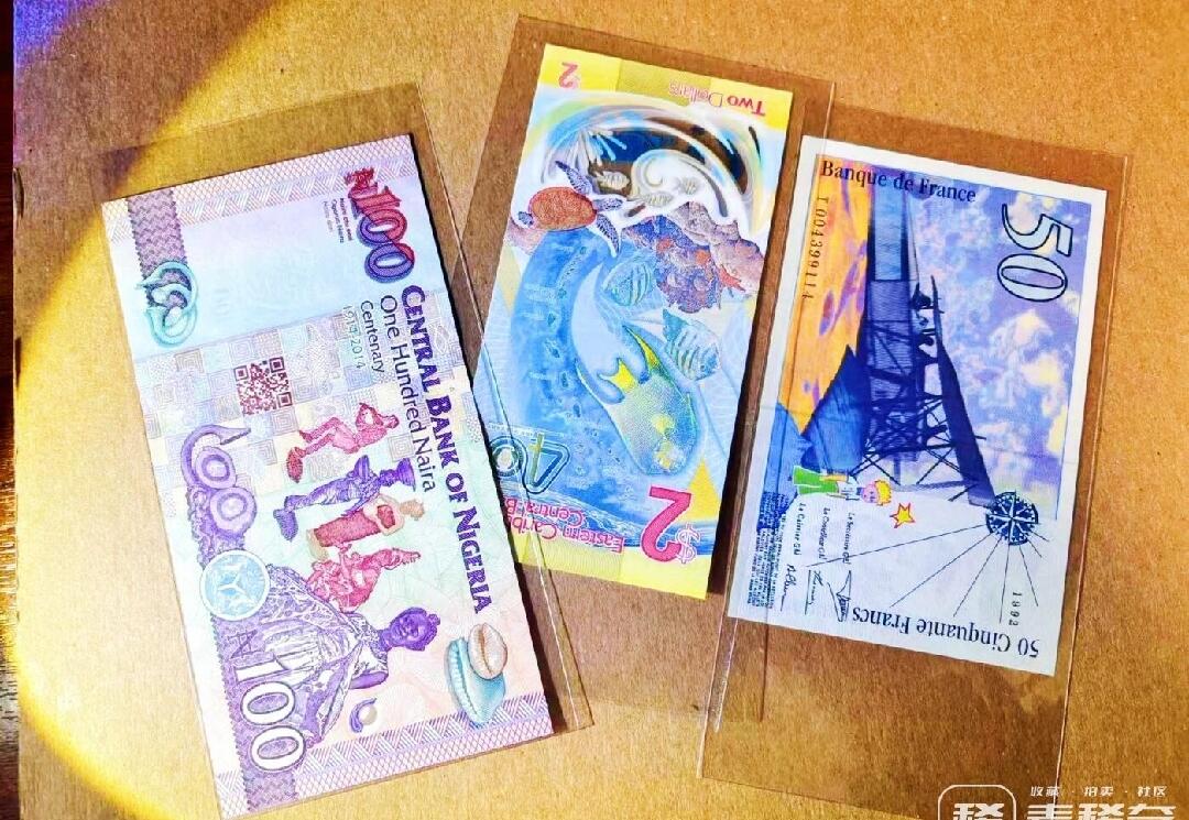 1992年法国50法郎 首年版 少见 正面肖像左侧的生卒年份和姓名在同一行 后期版本分两行 肖像人物为法国作家、飞行员圣埃克苏佩里 代表作《小王子》 钞票正反面均有小王子简笔画 背面是苏佩里飞越沙漠时驾驶的轰炸机 凑齐首年版末代法郎最难找的一张 赠送2024年IBNS获奖钞东加2元纪念钞（AA冠无47）和2014年IACA获奖钞尼日利亚100奈拉纪念钞