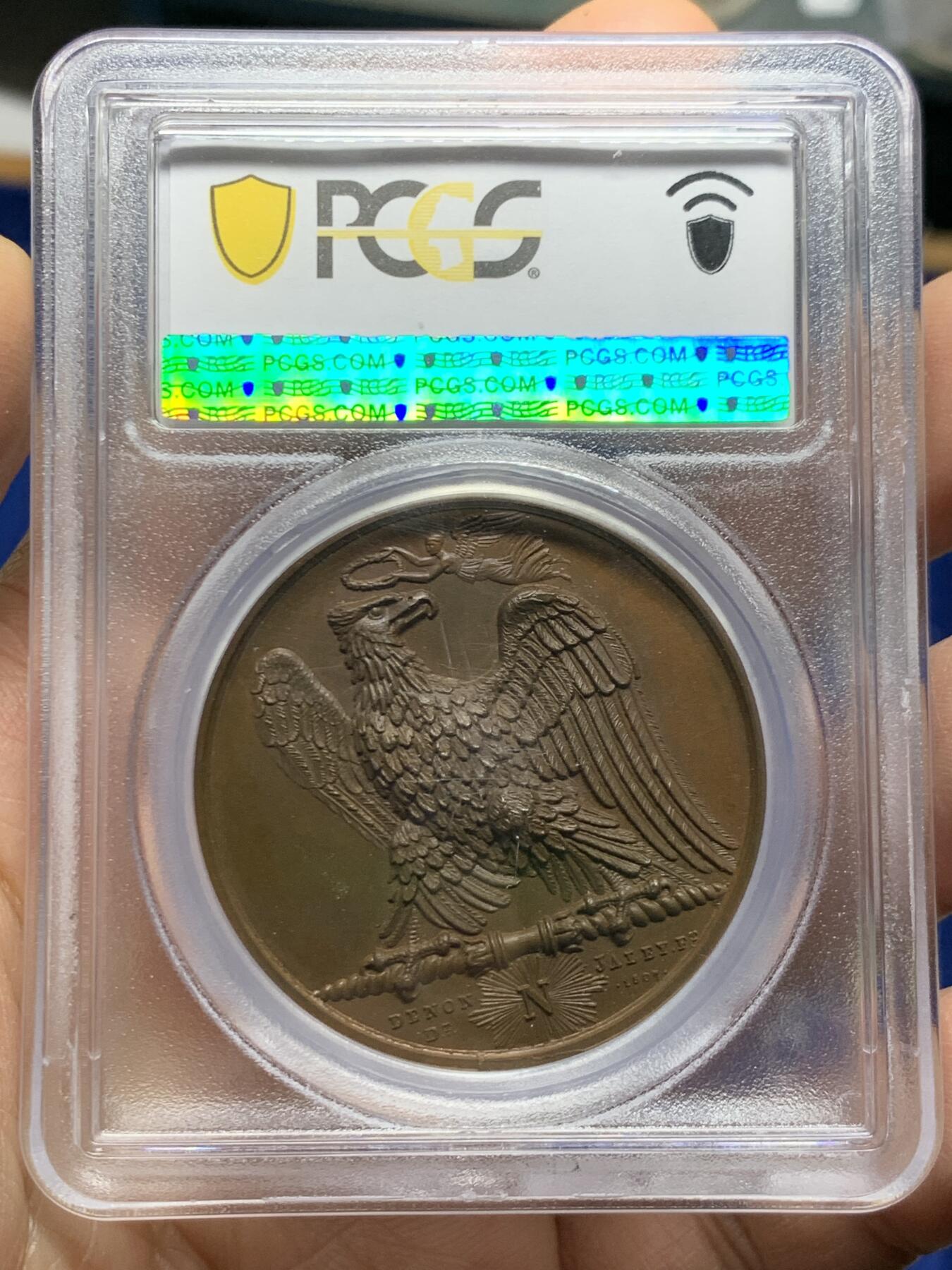 《竞宝斋》第461场 周日，周一，2场连拍 （全场包邮）欢迎送拍 PCGS SP65 冠军分！法国1807年拿破仑一世年度胜利原铸铜章 巴黎造币厂 巧克力包浆 帝国之鹰展翅爪子锋利 紧紧攥住矗立于N记雷电权杖之上 目光锐利如炬 羽翼丰满 丝缕清晰细节感人 作为拿皇的拟人化象征 接受上空胜利女神飞舞空中送来月桂花环为其加冕 作为年度总结庆祝过去的一年中军队获取的胜利 稀少珍贵品种 加厚盒
