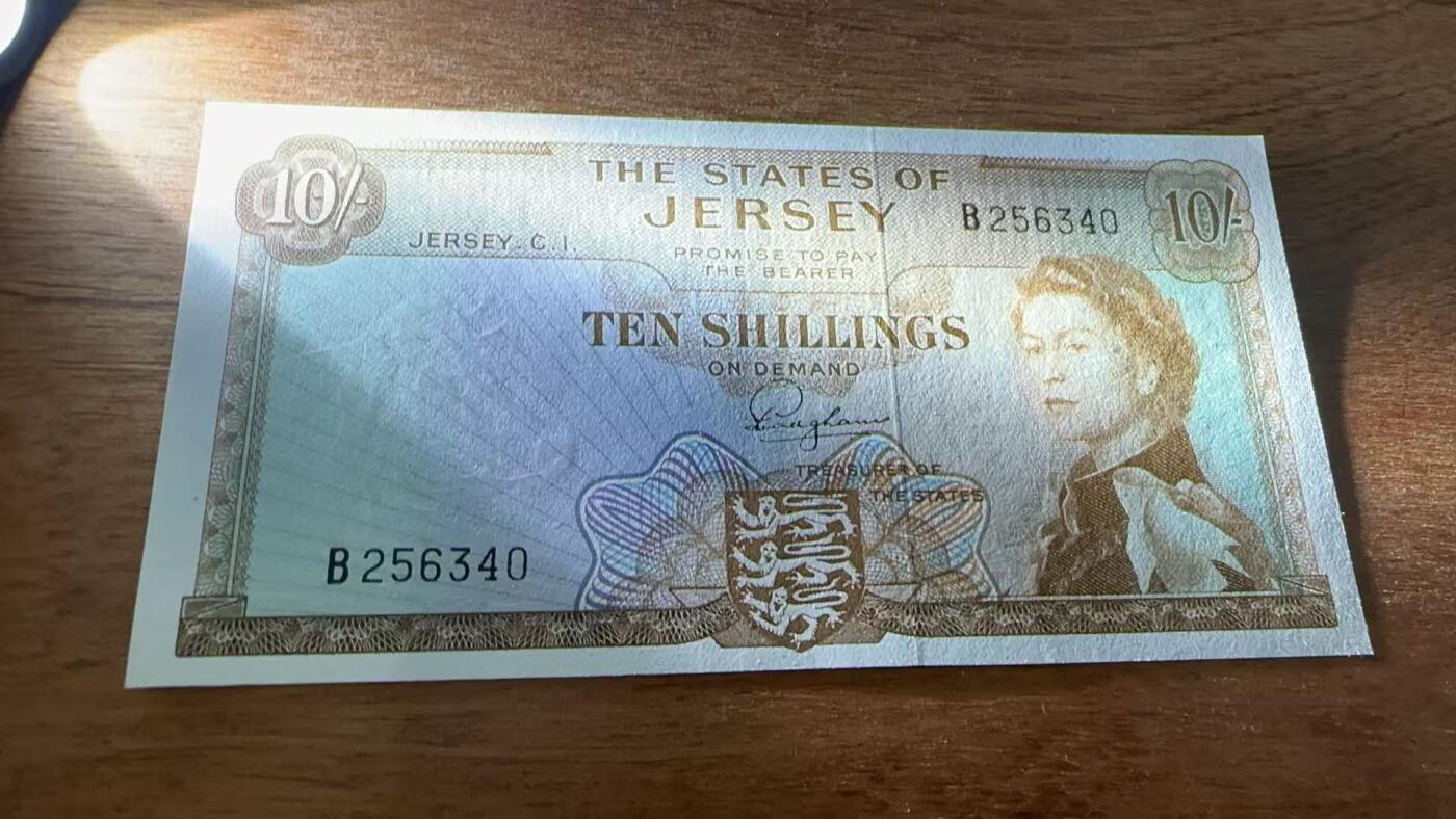 徐霞客拍卖首拍 泽西岛	P-7 1963年10先令	UNC- B256340			发行于20世纪中后期，是泽西岛当时流通的法定货币。它融合了英联邦货币风格与本土标识的设计，以君主肖像为核心元素，兼具流通功能与身份象征意义，见证了泽西岛货币体系的独立发展与英联邦金融关联，是研究该地区金融史与殖民文化传承的实物佐证。其收藏价值源于存世量稀少，在小众地域货币收藏中独具辨识度。	