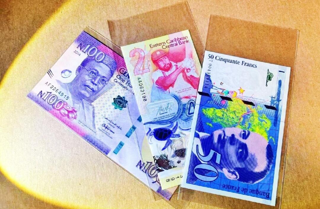 1992年法国50法郎 首年版 少见 正面肖像左侧的生卒年份和姓名在同一行 后期版本分两行 肖像人物为法国作家、飞行员圣埃克苏佩里 代表作《小王子》 钞票正反面均有小王子简笔画 背面是苏佩里飞越沙漠时驾驶的轰炸机 凑齐首年版末代法郎最难找的一张 赠送2024年IBNS获奖钞东加2元纪念钞（AA冠无47）和2014年IACA获奖钞尼日利亚100奈拉纪念钞