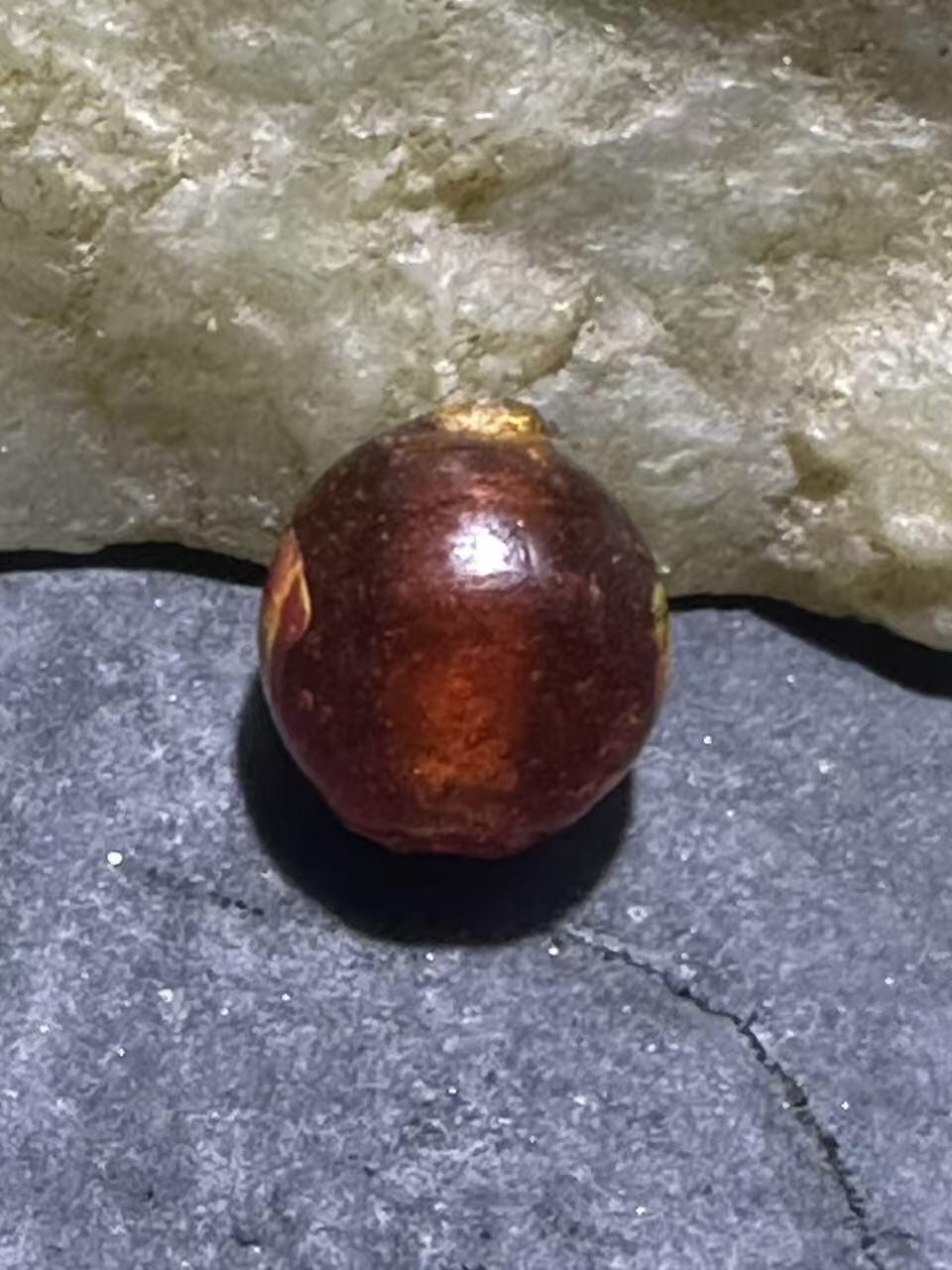 建国前后库存琥珀色祥云纹立体凤眼琉璃珠一颗，