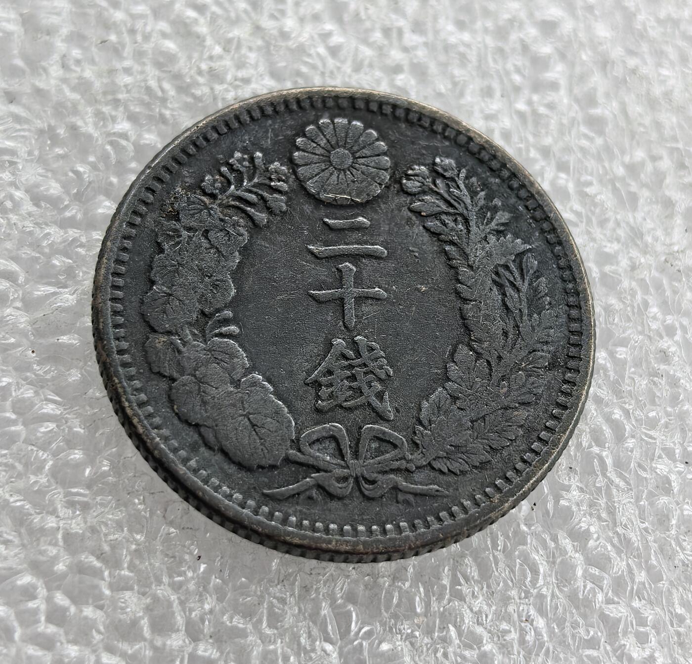 外国优质老铜币高银银币，周六九点倒数截拍，满百包邮，持续收拍 明治三十八年（1905 年）日本二十钱银币，正面皇室菊纹、“二十钱” 配桐叶花环，彰显皇权与传统；背面 “大日本 明治三十八年”、龙纹与 “20 SEN”，龙纹受中国文化影响。明治维新后日本币制改革，此币是近代化与对外扩张初期的货币见证。
