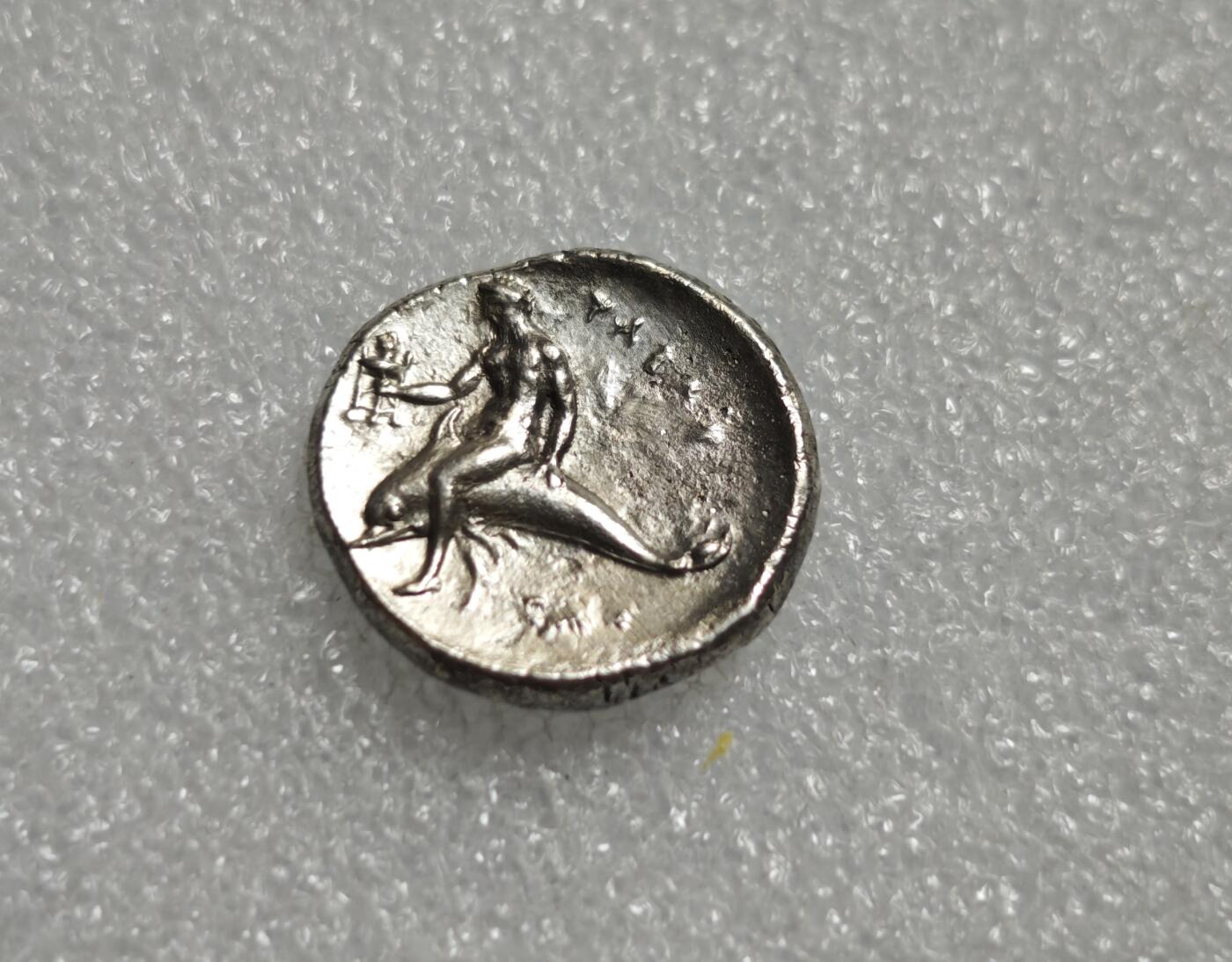 瓶子🏺第227期拍卖会  古希腊时期卡拉布里亚地区（大希腊）塔兰托（Tarent）铸造的迪德拉克马银币，铸造时间大约在公元前390年至380年  钱币的正面图案为一名青年骑在马上  背面图案为塔兰托的守护神塔拉斯（Taras）骑在海豚上 好品版本稀少  塔拉斯手持圣器三足祭坛 