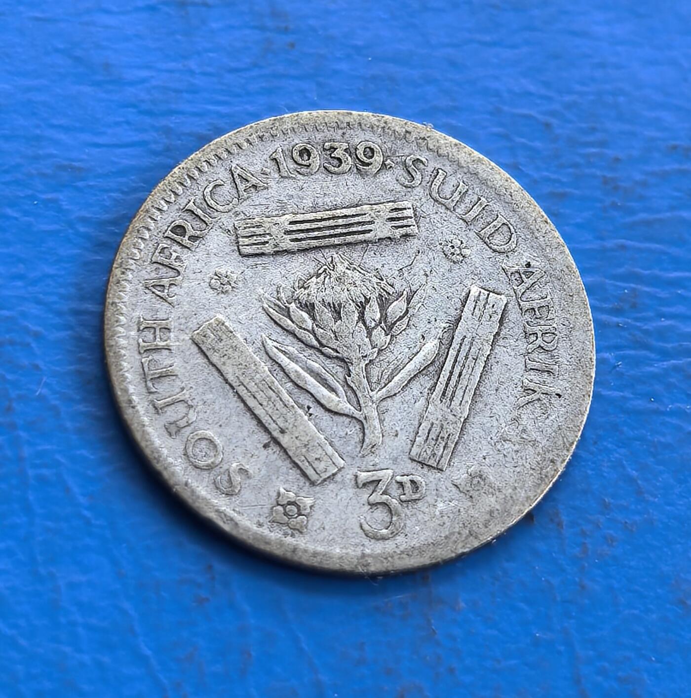 外国优质老铜币高银银币，周六九点倒数截拍，满百包邮，持续收拍 南非1939 年 3 便士银币，正面乔治六世头像雕刻细腻传神，帝国铭文环绕排布规整；背面帝王花居中，英、南非双语国名与 3D 面值搭配，本土花卉元素鲜明，银质包浆温润，兼具英伦风格与南非地域特色，工艺精致。