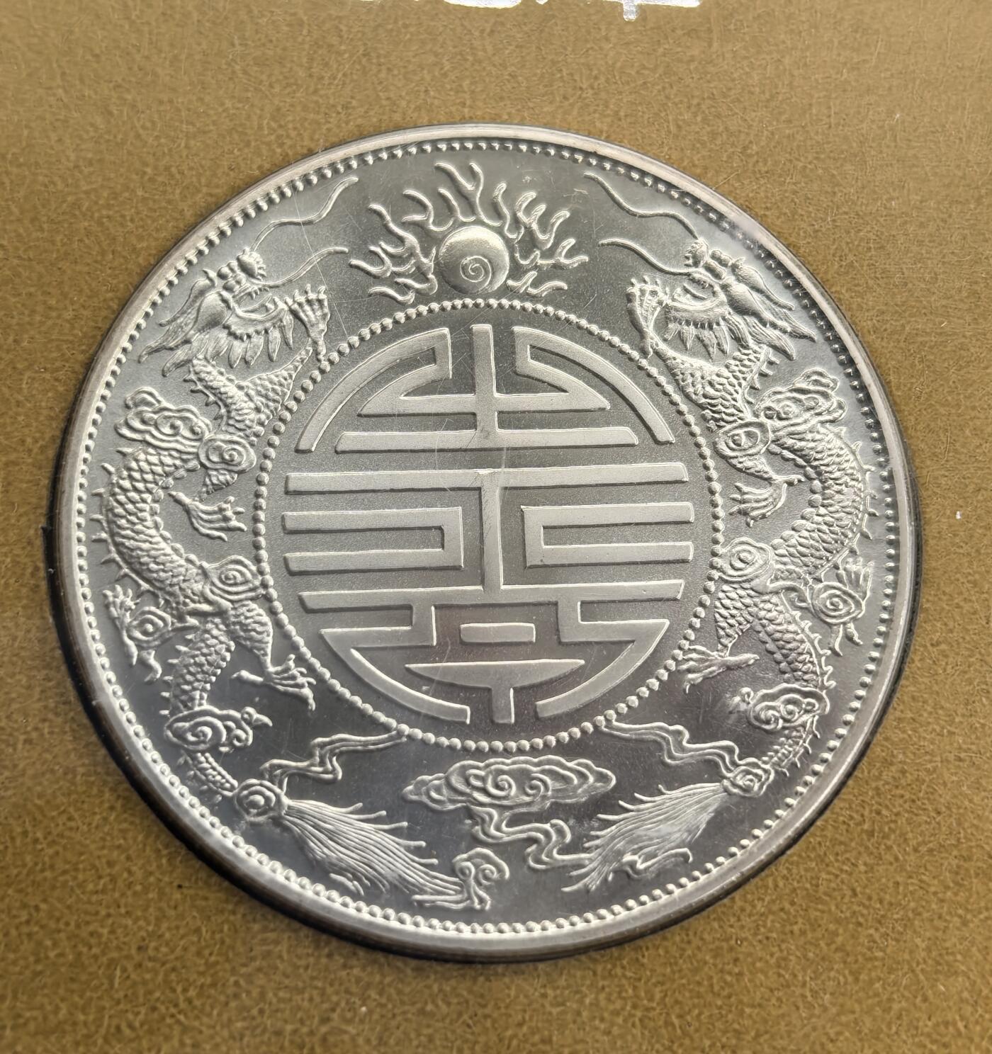 外国优质老铜币高银银币，周六九点倒数截拍，满百包邮，持续收拍 造币厂官方出广东寿字壹两银币纪念章带证书，直径39.4mm正面复刻光绪元宝寿字壹两原币图案，背面为寿字纹双龙戏珠，中英文纪念章铭文清晰，上海造币厂精制，还原经典银币神韵，工艺精湛，兼具收藏与纪念价值。