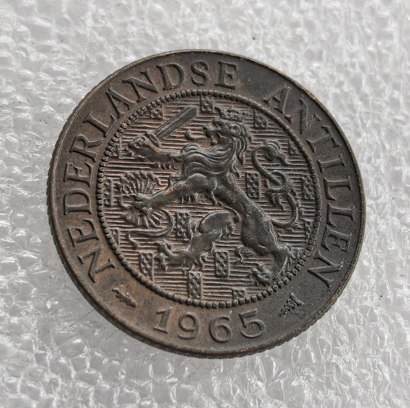 外国优质老铜币高银银币，周六九点倒数截拍，满百包邮，持续收拍 带光1965 年荷属安的列斯 2½ 分铜币，正面铸面值与花环纹饰，背面标注领地名、荷兰雄狮纹章（荷兰王室象征）及年份。属荷兰海外领地时期，是荷兰对安的列斯殖民统治、推行殖民货币体系的流通辅币见证。