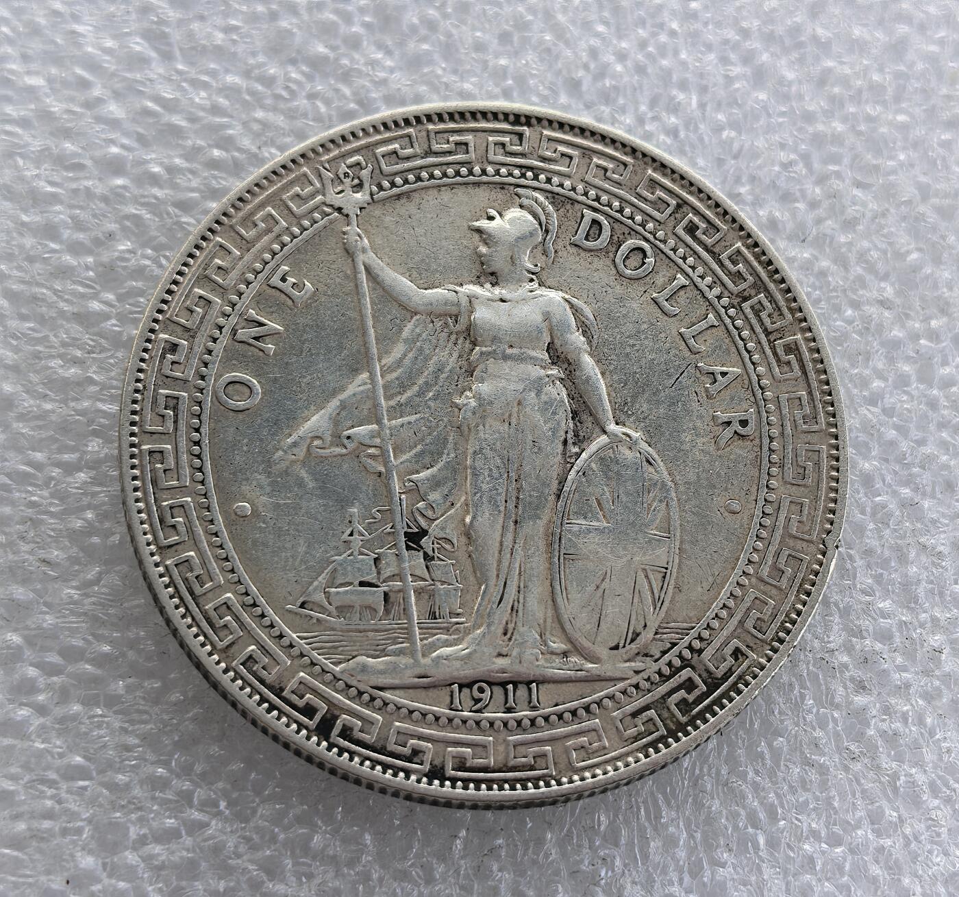 外国优质老铜币高银银币，周六九点倒数截拍，满百包邮，持续收拍 1911 年英国贸易银元（站洋）壹圆银币，正面为持三叉戟、盾的不列颠女神，下有帆船与年份；背面铸 “壹圆”、寿字纹及阿拉伯文，外圈回纹。为晚清至民国流通的国际银圆，见证中英贸易史，是经典外国银圆品种。表面有过处理，未入盒