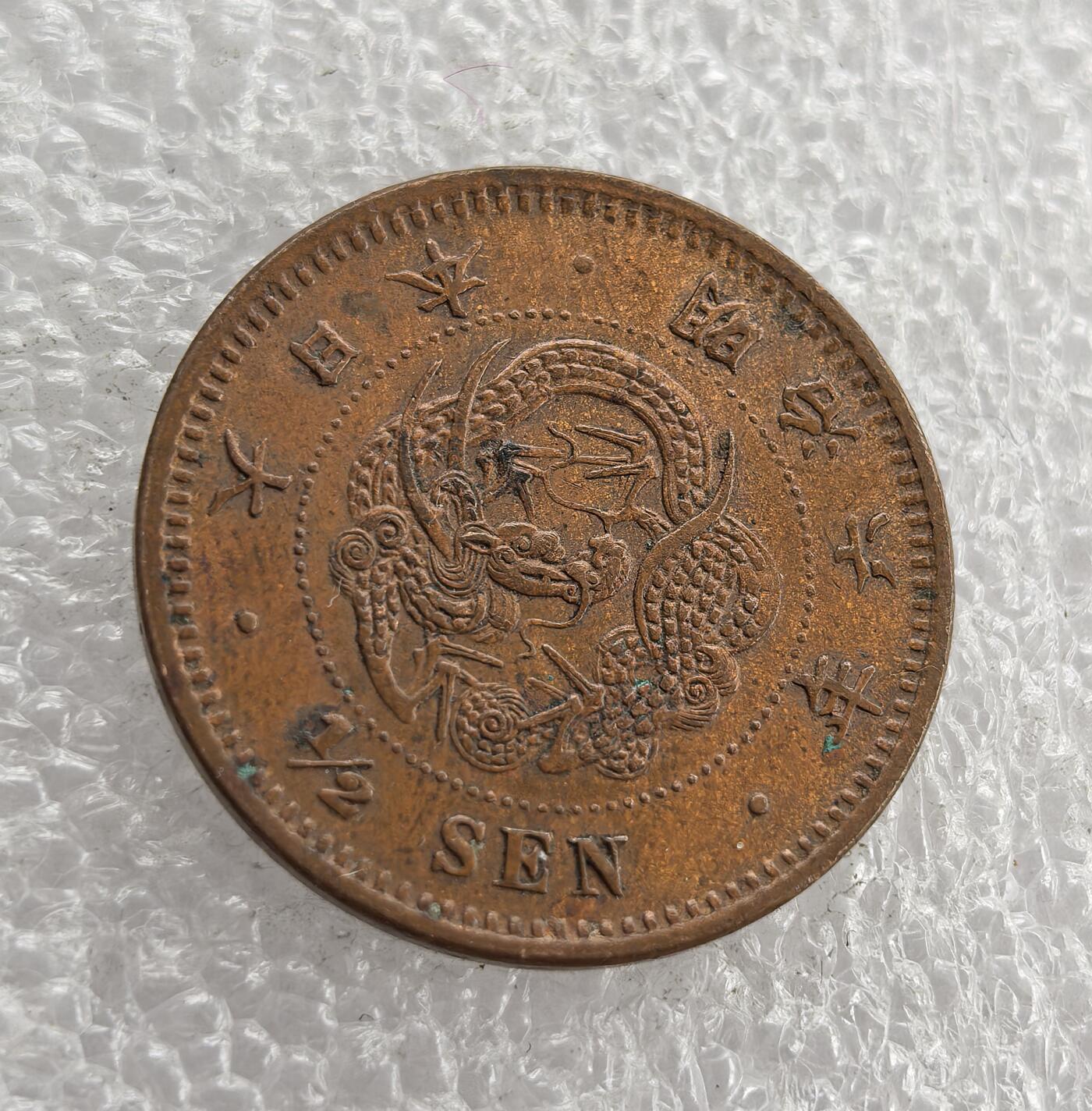 外国优质老铜币高银银币，周六九点倒数截拍，满百包邮，持续收拍 日本明治六年半钱铜币，正面铸龙纹、国名与面值，背面饰半钱、桐叶菊纹及兑换比例，属明治时期经典龙纹辅币。百年铜质包浆自然醇厚，龙纹清晰、品相完整，是东亚近代货币收藏的精品，历史与收藏价值兼具。