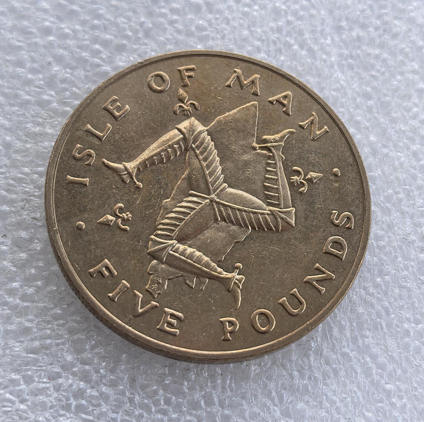 外国优质老铜币高银银币，周六九点倒数截拍，满百包邮，持续收拍 英属马恩岛1981 年 5 镑纪念币，正面铸伊丽莎白二世头像，背面为马恩岛标志性三曲腿图（三腿人），搭配属地标识，属英联邦海外领地经典纪念币，三曲腿图是马恩岛核心文化象征，彰显其独特自治地位。