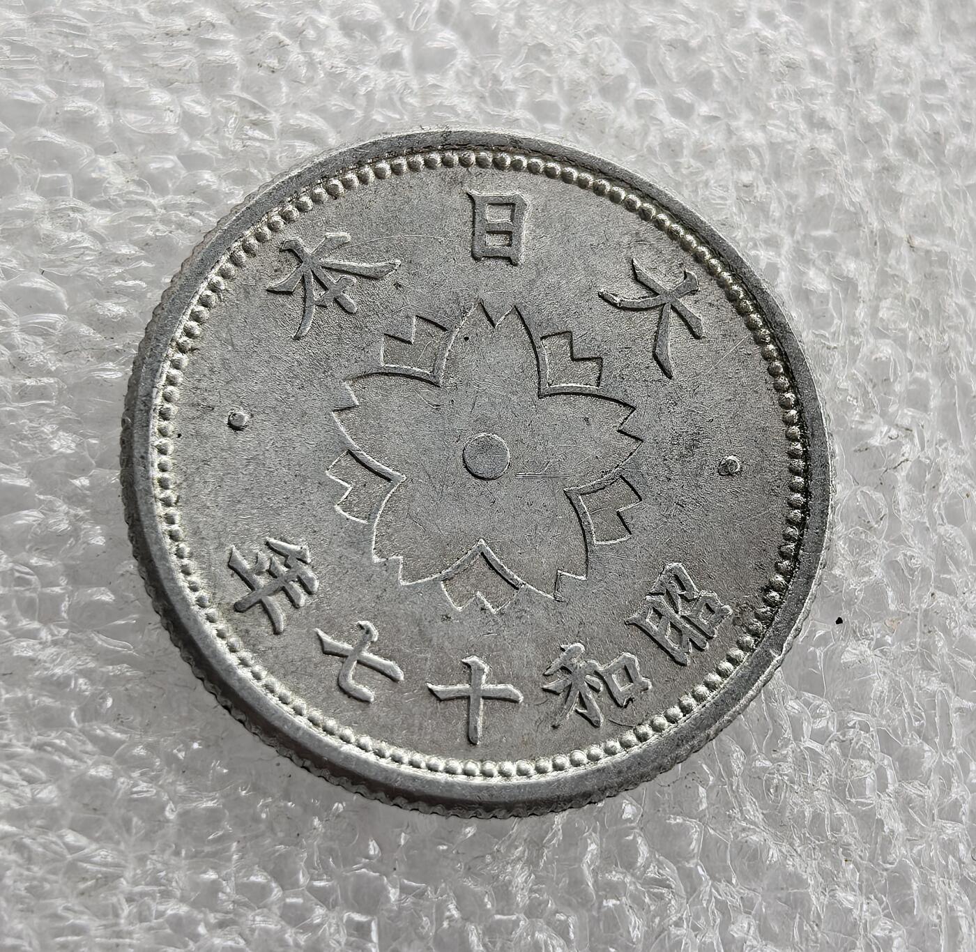 外国优质老铜币高银银币，周六九点倒数截拍，满百包邮，持续收拍 昭和十七年（1942 年）日本十钱铝币，正面皇室菊纹、“十钱” 与桐叶纹彰显皇权与传统；背面 “大日本 昭和十七年” 配樱花纹。二战时期日本金属匮乏改用铝铸，是战时经济与军国主义扩张的货币实物见证。