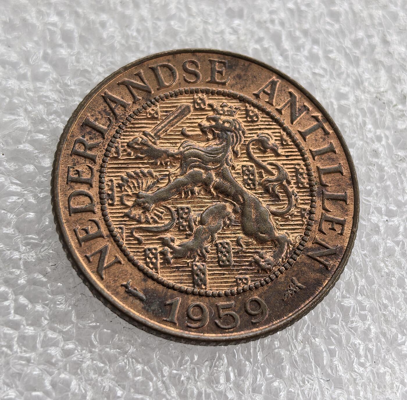 外国优质老铜币高银银币，周六九点倒数截拍，满百包邮，持续收拍 原光1959 年荷属安的列斯 2½ 分铜币，正面铸面值与花环纹饰，背面标注领地名、荷兰雄狮纹章（荷兰王室象征）及年份。属荷兰海外殖民领地时期，是荷兰对安的列斯殖民统治、推行殖民货币体系的流通辅币见证