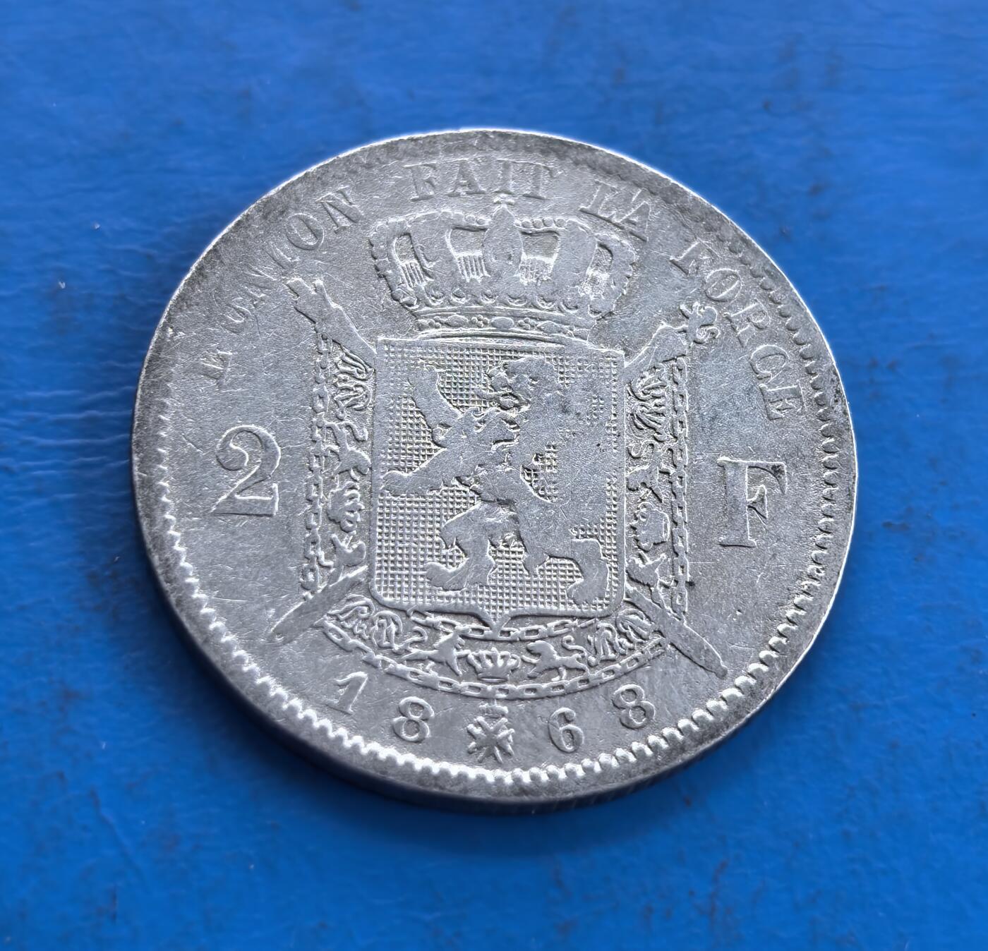 外国优质老铜币高银银币，周六九点倒数截拍，满百包邮，持续收拍 比利时1868年2 法郎银币，正面利奥波德二世头像雕刻细腻，胡须与面部轮廓传神；背面国徽雄狮威严，格言醒目，年份与面值规整，银币包浆古朴，纹饰与文字融合尽显钱币艺术魅力。