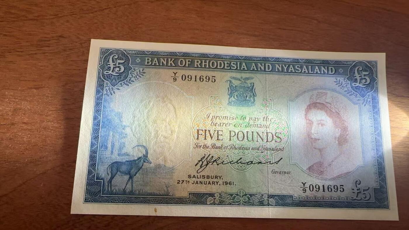 徐霞客拍卖首拍 罗得西亚和尼亚萨兰	P-22b 1961年5镑	Y/9 091695 品相如图 该联邦是英国在非洲东南部建立的短暂殖民联合体（1953–1963年），仅在1956–1963年间流通，联邦解体后，三个成员国各自独立并发行了本国货币，因此这批纸币的流通周期极短。正面印有伊丽莎白二世肖像。是“英属中非联邦最后的货币遗产”，仅发行7年即退出历史舞台。真正的大珍品 极其难见				