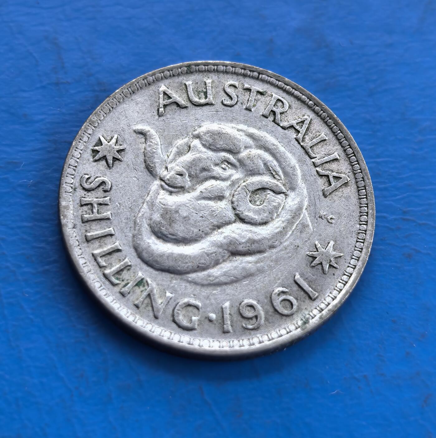 外国优质老铜币高银银币，周六九点倒数截拍，满百包邮，持续收拍 澳大利亚1961年1先令银币，正面为伊丽莎白二世女王侧面像，铭文彰显其君主身份；背面是澳洲原住民风格的蛇形图腾，搭配星纹与纪年，兼具英国王室印记与本土文化特色，是澳大利亚货币体系转型前的经典币种。