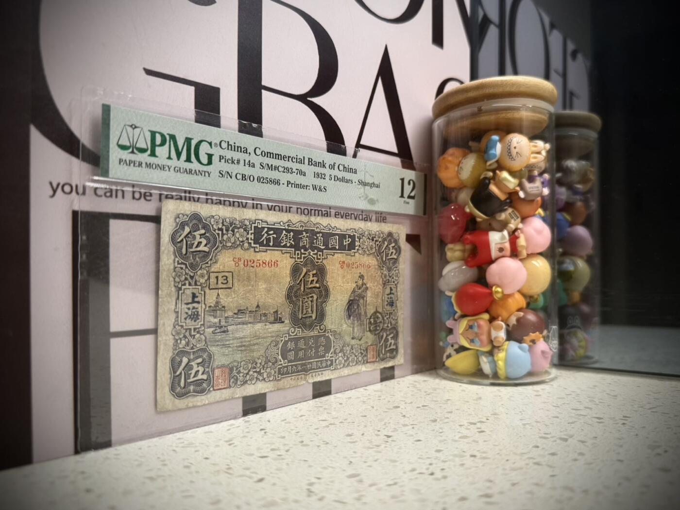 （自动截拍）PMG评级民国纸币专拍第20260131期，全场包邮 【乾奕收藏】出民国21年1932年中国通商银行上海地名伍圆，美国PMG12分，无背标，中间小透，号码全程无347双尾66双喜号， 左侧外滩，右财神图案