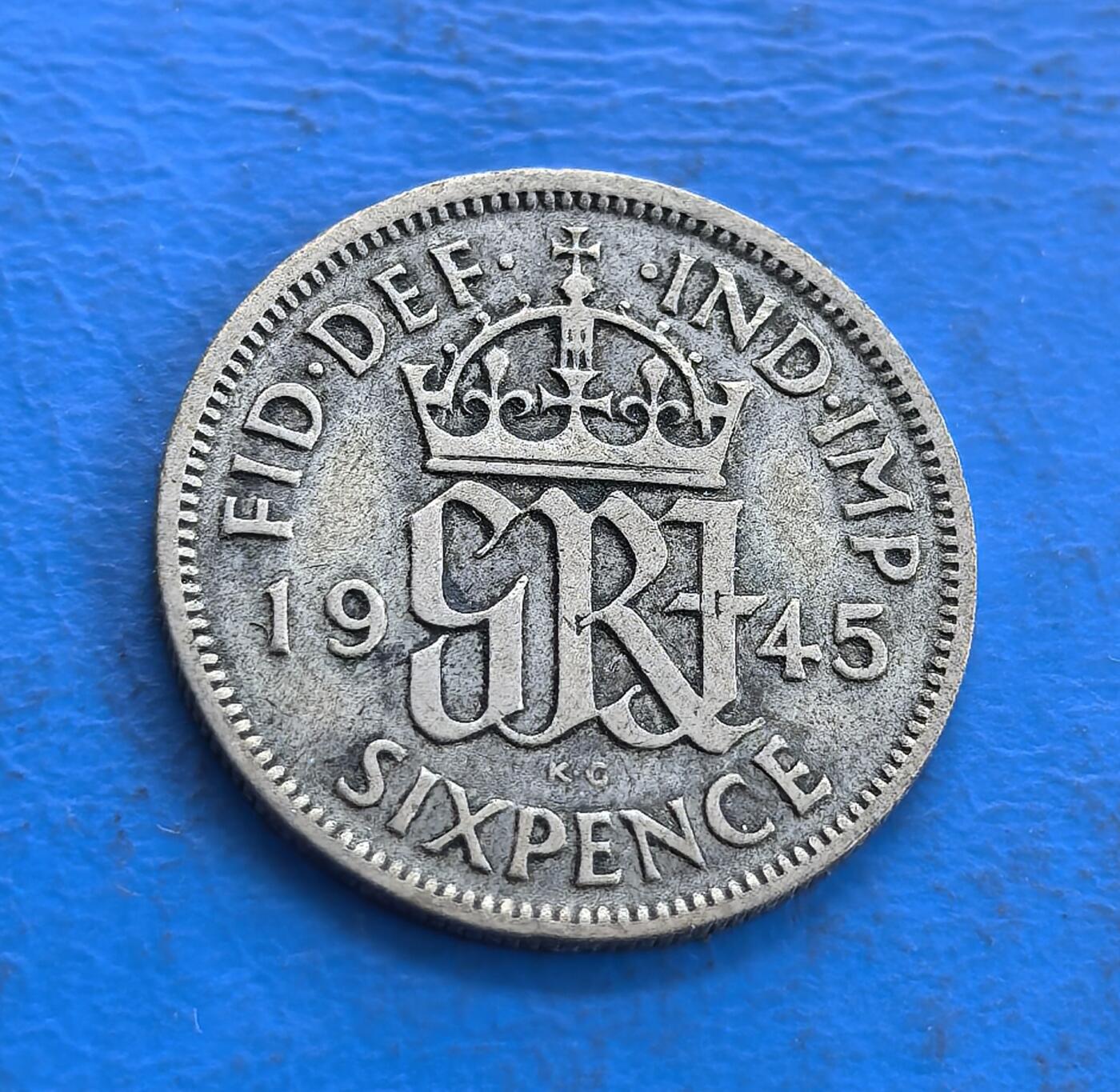 外国优质老铜币高银银币，周六九点倒数截拍，满百包邮，持续收拍 英国1945 年 6 便士银币，正面乔治六世头像雕刻细腻传神，铭文环绕排布规整；背面皇冠衬 GRVI 花押，面值、年份清晰醒目，纹饰庄重典雅，银质包浆温润，尽显二战时期英伦钱币的精湛工艺与经典美学。