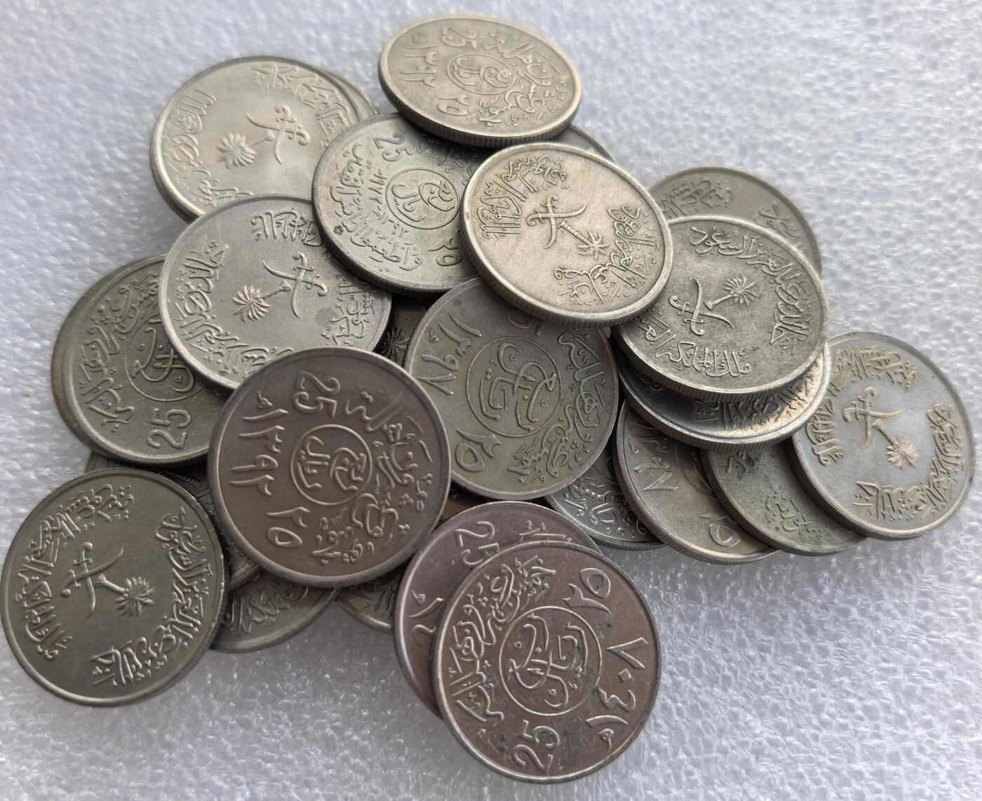 外国优质老铜币高银银币，周六九点倒数截拍，满百包邮，持续收拍 沙特阿拉伯25哈拉拉32枚，正面铸阿拉伯文、面值 “25” 及沙特国徽（椰枣树 + 弯刀），背面为阿拉伯文与年份，属沙特现代流通辅币，是中东钱币收藏的基础品种。