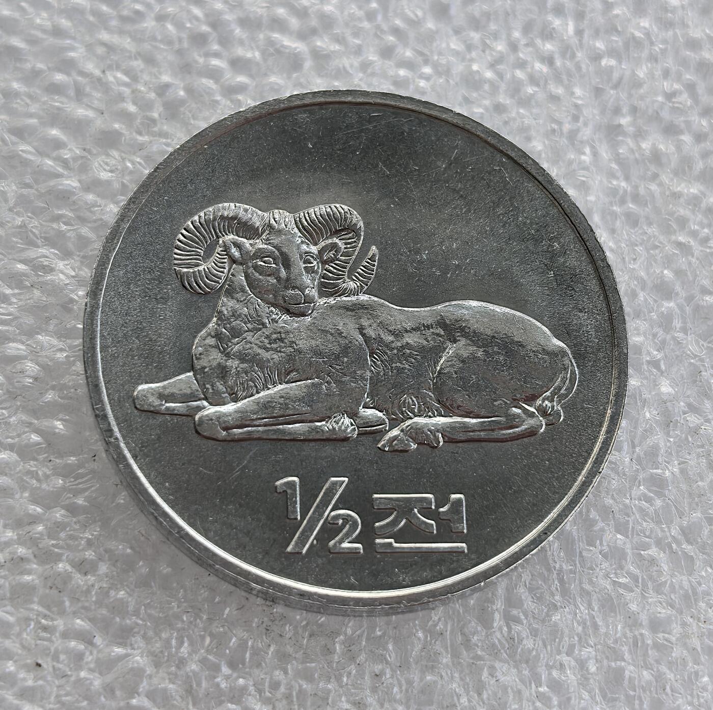 外国优质老铜币高银银币，周六九点倒数截拍，满百包邮，持续收拍 2002 年朝鲜民主主义人民共和国发行的 1/2 钱铝质辅币，正面铸盘角公羊图案，背面为朝鲜国徽及央行铭文，属朝鲜现代流通辅币，设计简洁，兼具国家象征与地域动物特色，是朝鲜钱币收藏的基础品种。