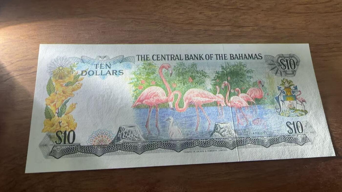 徐霞客拍卖首拍 	巴哈马群岛	P-38a 1974年10元				J645661	unc-纸币正面以伊丽莎白二世肖像为核心设计元素，体现英联邦国家的历史关联。该币是巴哈马独立后首批发行的法定货币，反映其政治转型与经济自主的进程。采用西班牙大帆船水印、精细雕刻凹印及多色套印技术防伪，背面的海洋生物与岛屿图案则展现巴哈马的自然地理特征。		