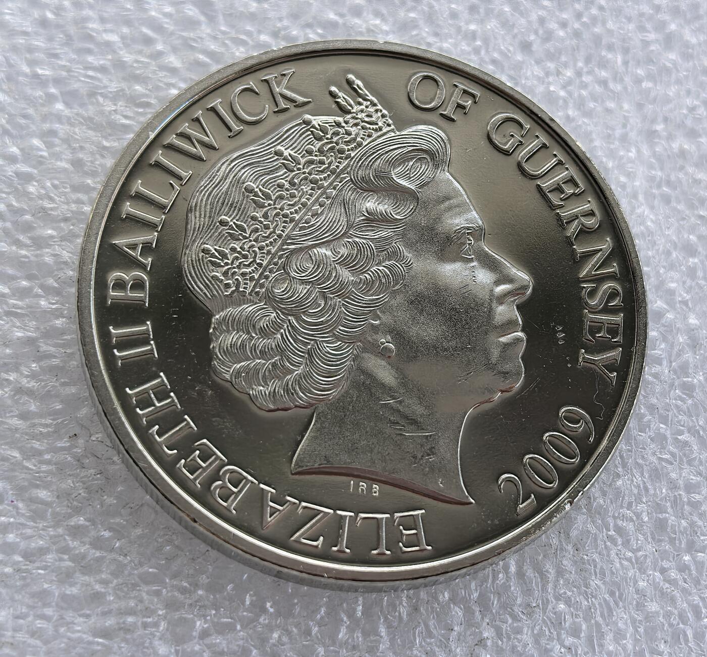 外国优质老铜币高银银币，周六九点倒数截拍，满百包邮，持续收拍 英属根西行政区 2009 年 5 镑纪念币，为纪念阿波罗 11 号人类首次登月 40 周年（1969-2009）打造。正面铸伊丽莎白二世头像与属地标识，背面刻画登月舱、宇航员登月球场景并镶嵌地球，铭文 “ONE SMALL STEP” 致敬登月壮举，属英联邦航天主题经典纪念币。